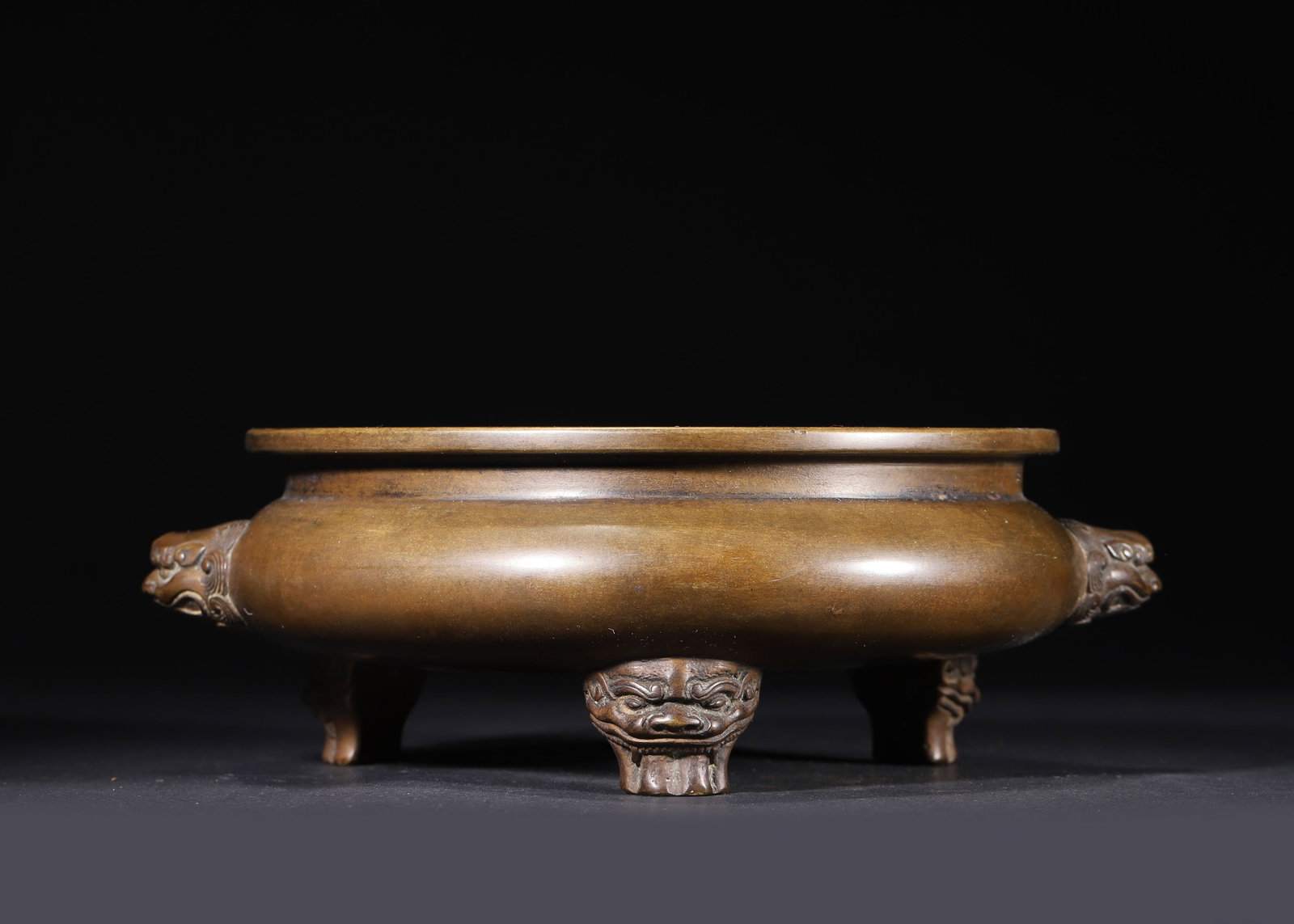 EARLY QING DYNASTY, A BRONZE TRIPOD CENSER WITH 'NEI YONG' MARK AND BEAST HANDLES & FEET: 9.06" x 3.15" (23.0cm x 8.0cm) 5.512lb (2500g)This robust Early Qing bronze censer, bearing the imperial 'Nei Yong' mark, features beast-head handles and tripod feet, a rich aged patina, and a finely 