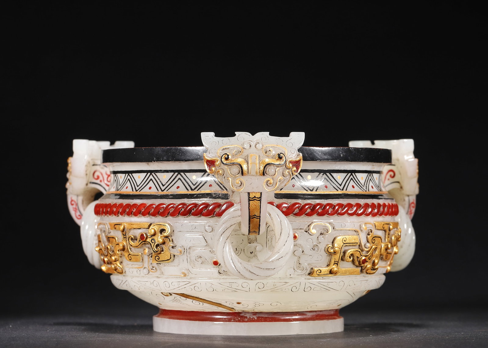 HAN DYNASTY HETIAN WHITE JADE GUI VESSEL WITH GOLD & POLYCHROME DECORATION, FOUR LOOPED HANDLES: 6.3in (16.0cm) 1.96lb (889.0g)A magnificent Han Dynasty jade gui vessel carved from fine Hetian white jade. Features four movable ring handles, exquisite gold and polychrome decoration, and archaic dr
