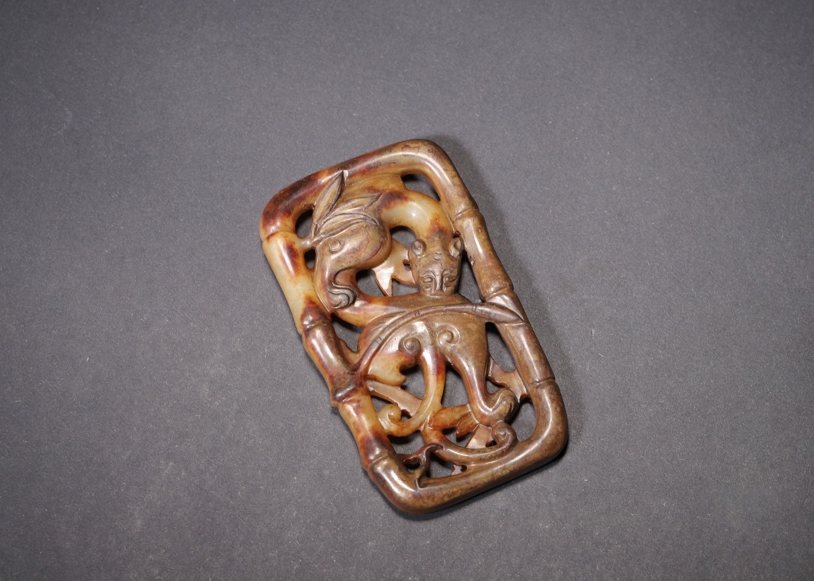 MING DYNASTY YELLOW JADE OPENWORK BELT PLAQUE WITH BAMBOO AND CHI DRAGON MOTIF: 3.15in x 1.85in (8.0cm x 4.7cm) 0.121lbs (55g)A fine Ming Dynasty yellow jade openwork belt plaque, carved with a dynamic chi dragon and mythical beast within a bamboo frame. The intricate openwork, w