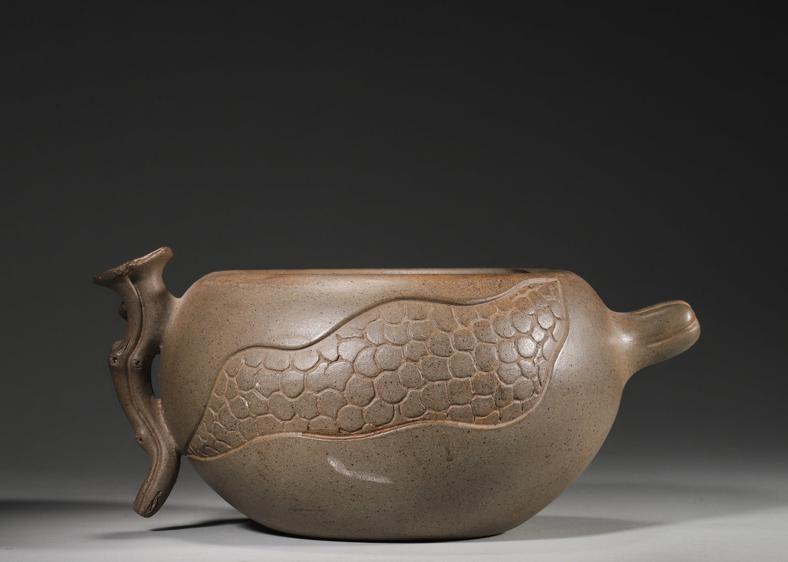 QING DYNASTY KANGXI PERIOD ZISHA FAIRNESS CUP BY CHEN MINGYUAN, BIONIC POMEGRANATE DESIGN: 10.04in x 7.09in x 4.72in (25.5cm x 18.0cm x 12.0cm)Crafted by master Chen Mingyuan during the Kangxi reign, this Zisha fairness cup is made of fine blue-grey duan clay. It features a lifelike pomegra