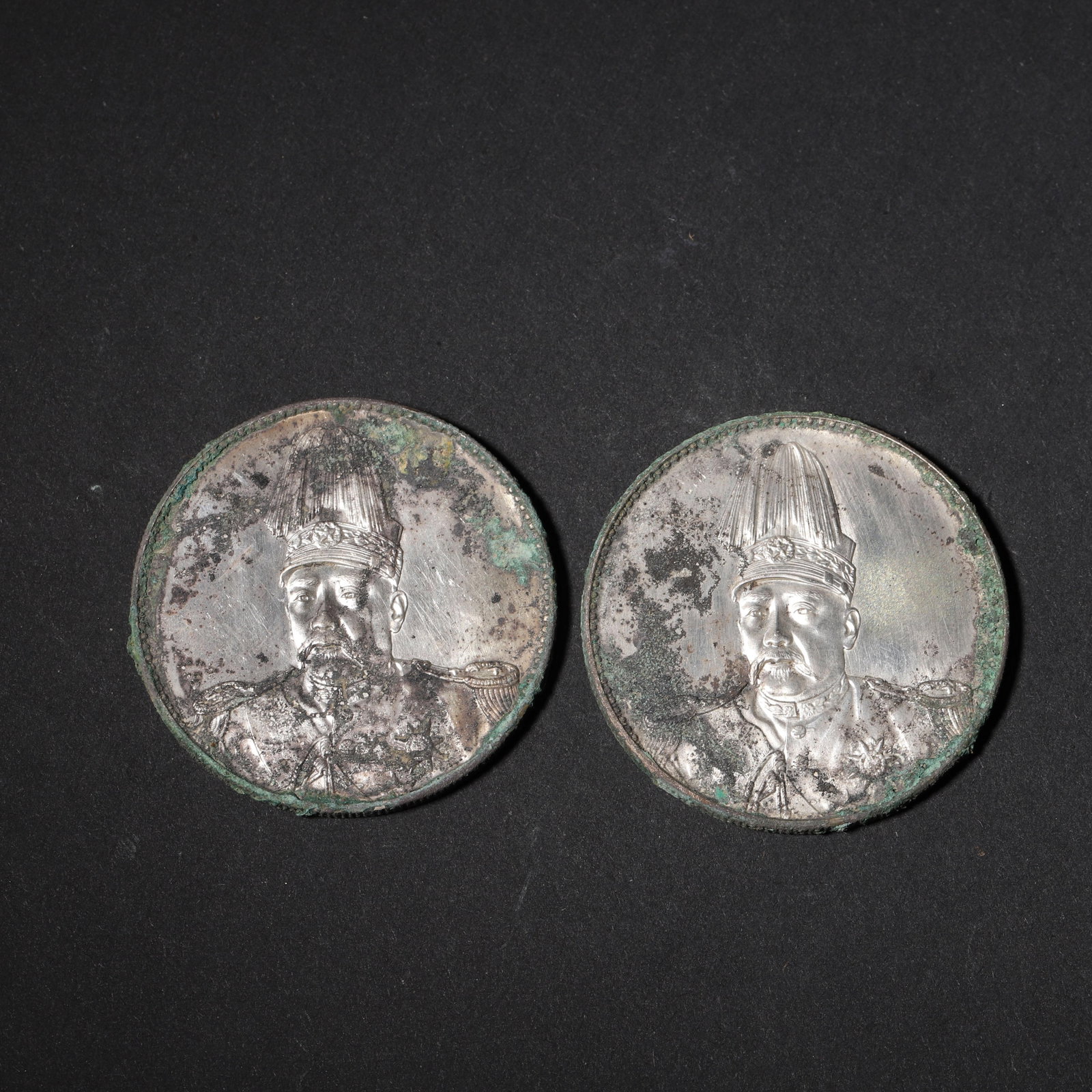 SET OF TWO YUAN SHIKAI COMMEMORATIVE SILVER COINS: FLYING DRAGON & REPUBLIC,Republic of China: 1.57in (4.0cm) 0.121lbs (55g)This set features two rare silver coins with rich patina. One displays Yuan Shikai in a tall hat with a flying dragon reverse; the other features the same portrait with gr