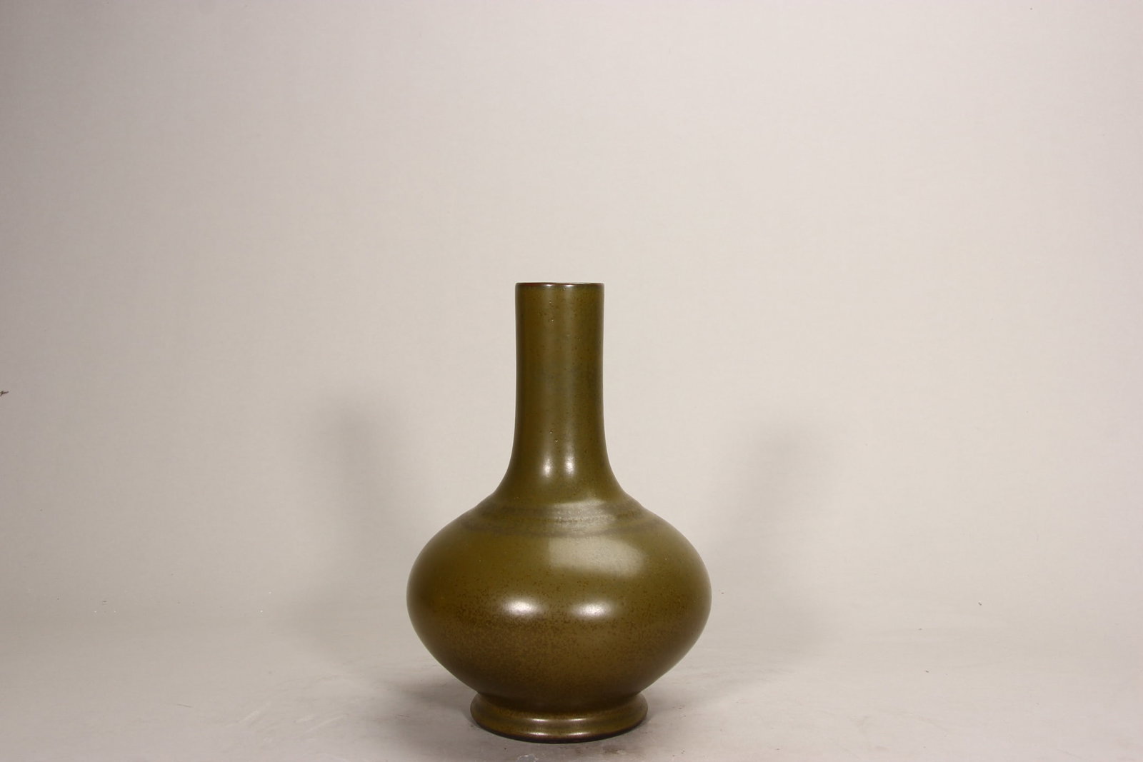 A FINE QING QIANLIANG PERIOD TEA-DUST GLAZED BIXI VASE: H8.62in (H21.9cm)This imperial vase features a robust form covered in rich tea-dust glaze with fine crystalline speckles. A superb example of Qianlong’s monochrome porcelain, embodying the elegance 