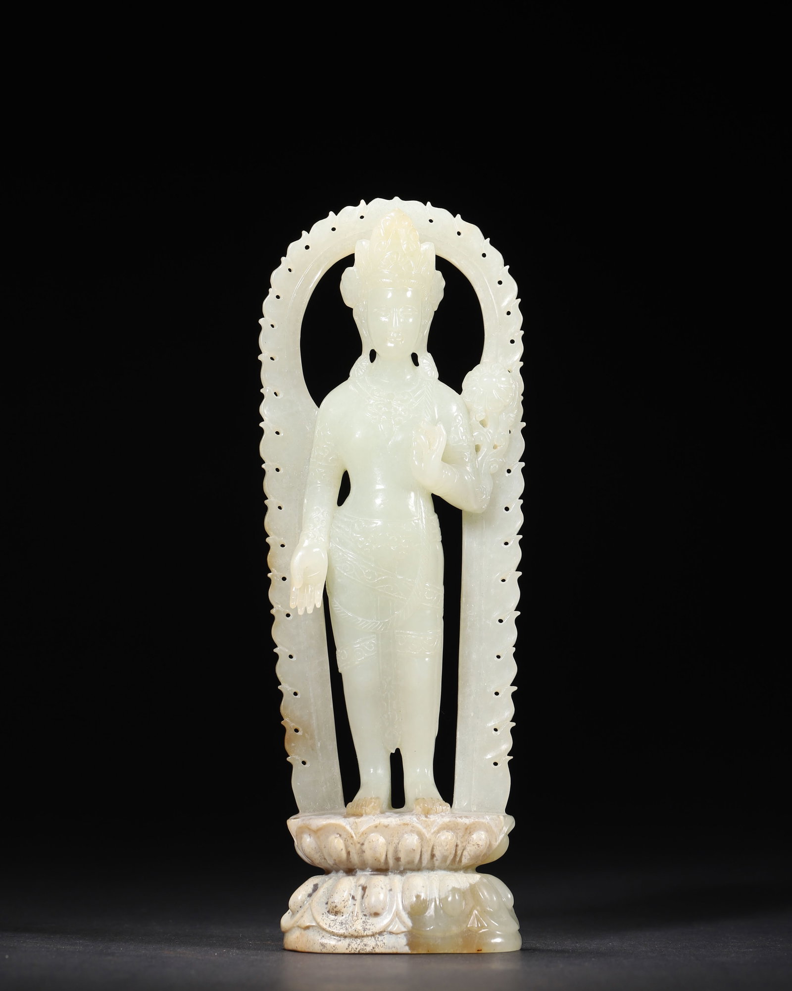 A FINE HETIAN GREENISH WHITE JADE STANDING GUANYIN WITH AUREOLE, MID-QING DYNASTY: 2.56in x 1.18in x 7.09in (6.5cm x 3.0cm x 18.0cm), 0.692lb (314.0g)This exquisite Mid-Qing Hetian greenish white jade Guanyin stands on a double lotus base, with an openwork flame aureole. Its serene 