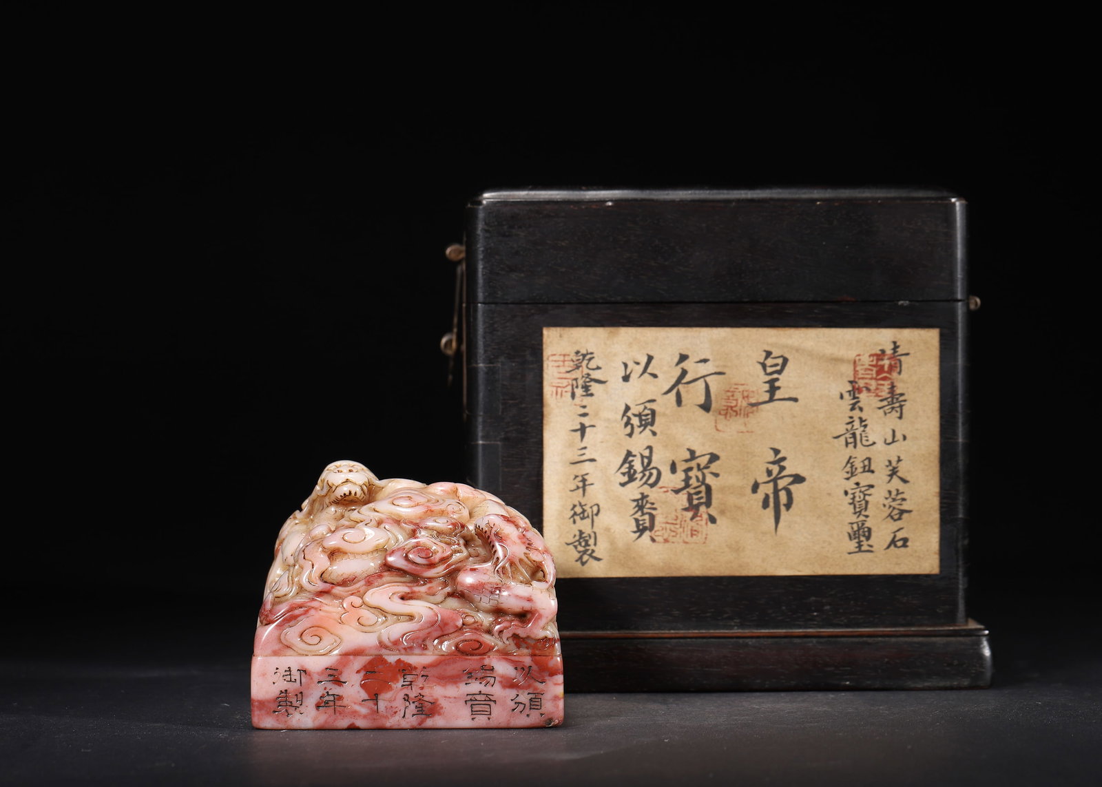 QIANLONG PERIOD, QING DYNASTY, A SHOUSHAN FURONG STONE IMPERIAL SEAL 'HUANG DI XING BAO' WITH CLOUD: 2.83" x 2.83" x 2.36" (7.2cm x 7.2cm x 6.0cm) 1.318lb (598g)Carved from Shoushan Furong stone, this imperial seal bears a cloud-dragon knob and an inscription dated 1758. It retains its original label