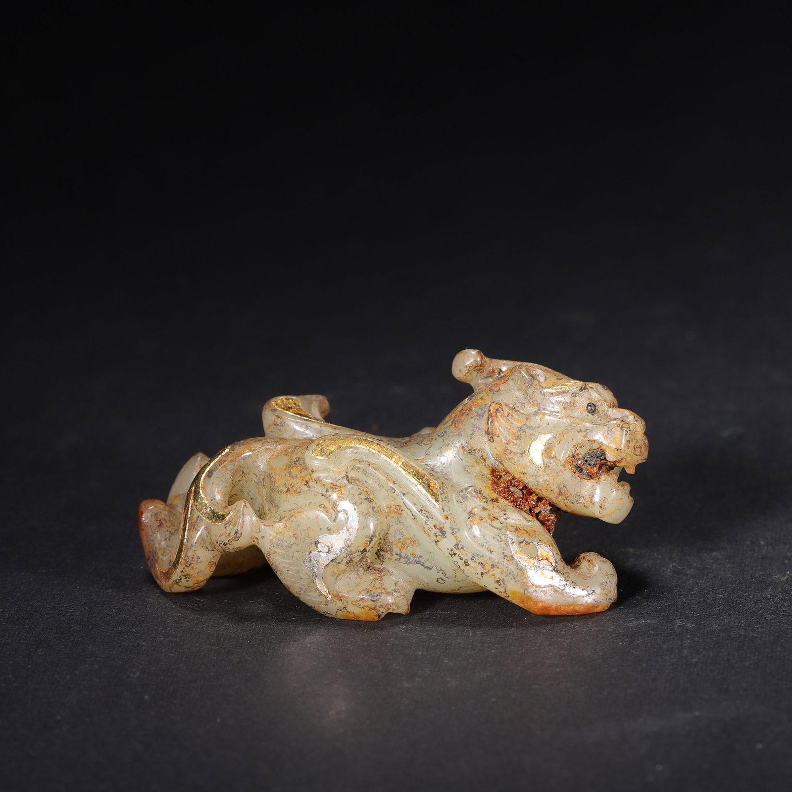 HAN DYNASTY GOLD & SILVER INLAID JADE PIXIU (MYTHICAL BEAST) ORNAMENT: 2.2" x 1.1" x 1.1" (5.6cm x 2.8cm x 2.8cm) 0.088lb (40g)This powerful Han Dynasty jade Pixiu, inlaid with gold and silver scroll patterns, crouches dynamically. Its aged earth patina and robust carvin
