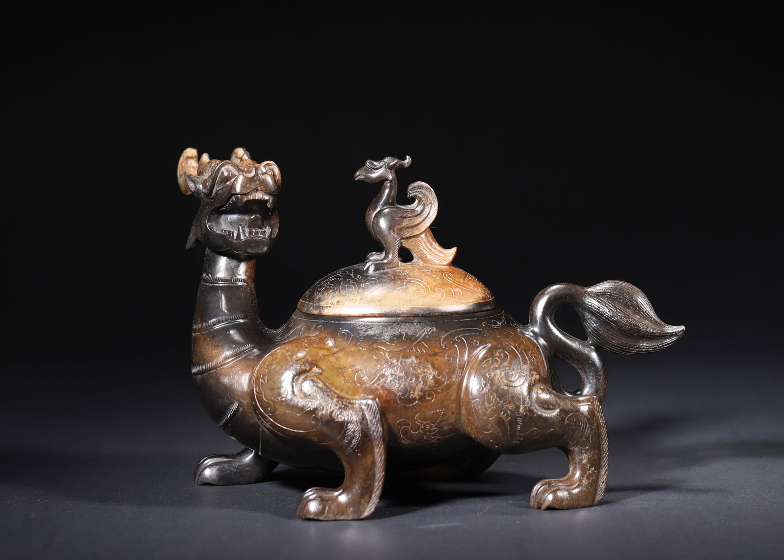 HAN DYNASTY HETIAN JADE MYTHICAL BEAST CENSER WITH DRAGON-PHOENIX FINIAL AND MERCURY PATINA: 9.06" x 4.72" x 5.91" (23cm x 12cm x 15cm) 3.75lb (1702g)Carved from Hetian jade, this Han Dynasty censer features a dragon-headed tortoise body and a phoenix finial. Adorned with intricate cloud patt
