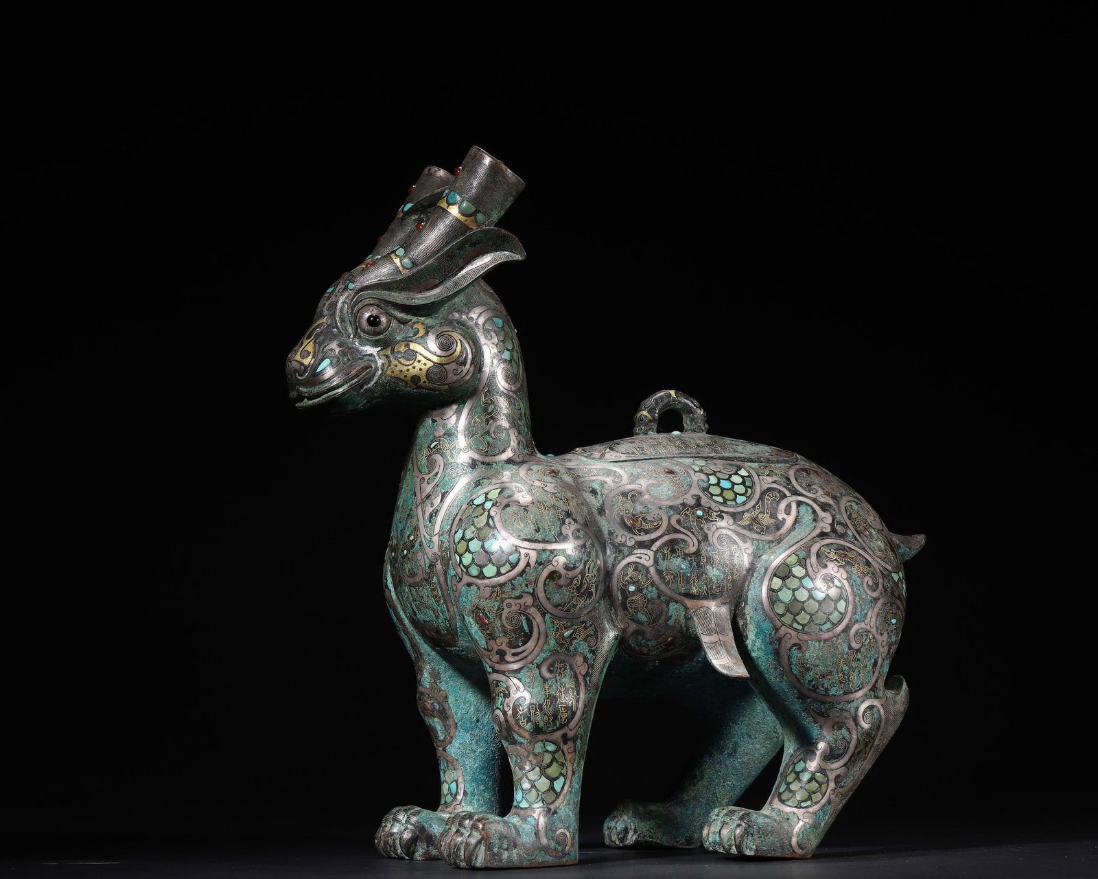 A MAGNIFICENT WARRING STATES TO HAN DYNASTY GOLD AND SILVER-INLAID BRONZE MYTHICAL BEAST ZUN VESSEL: 31x27cm (12.20x10.63in)This Warring States to Han Dynasty bronze zun vessel is exquisitely inlaid with gold, silver, turquoise, agate, and jade. Featuring a powerful mythical beast form and gold-inlai