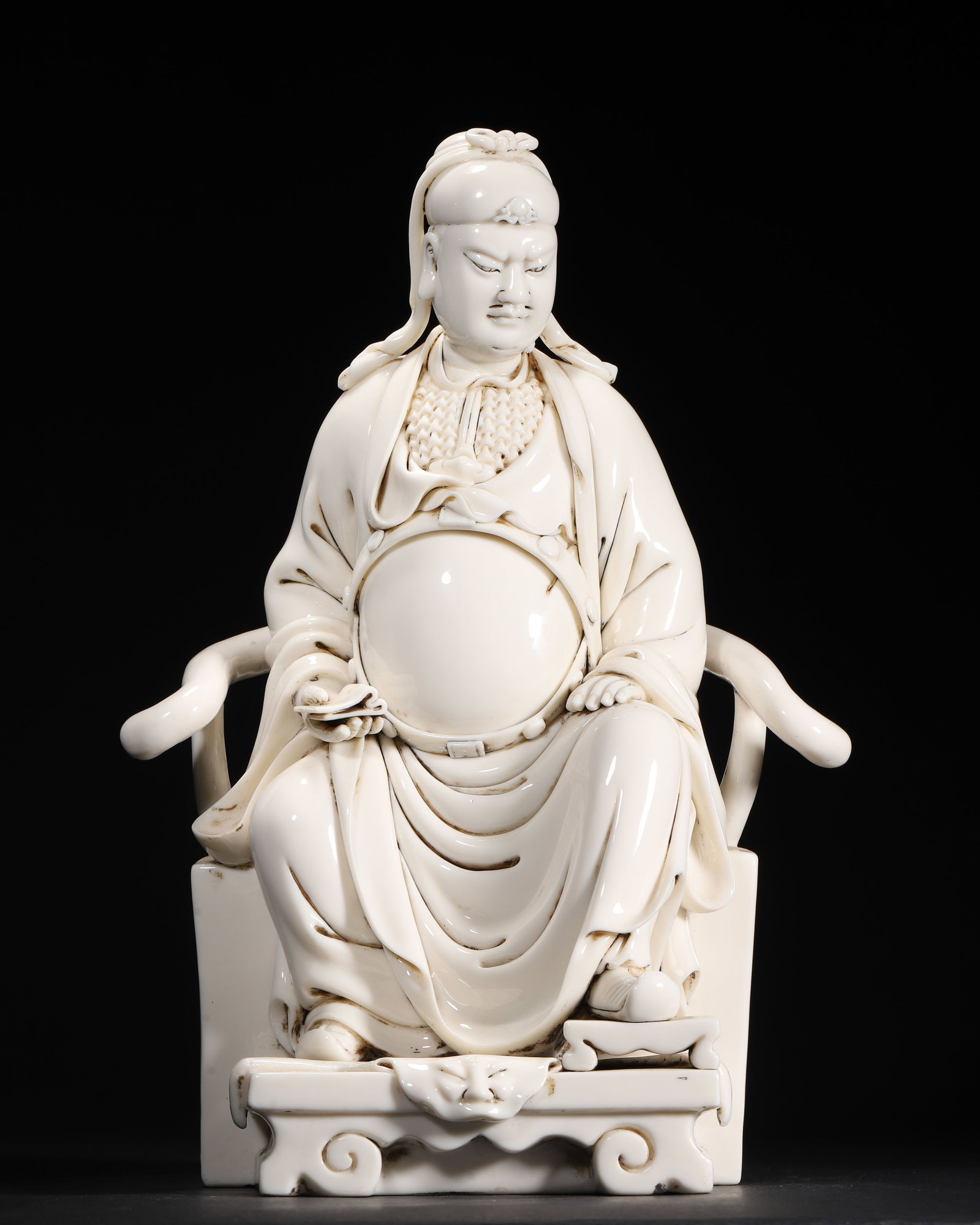 QING DYNASTY, A DEHUA WHITE-GLAZED SEATED FIGURE OF WENCHANG DIJUN, WITH SEAL MARK: 9.45" x 5.91" x 14.17" (24.0cm x 15.0cm x 36.0cm)This Dehua porcelain figure of Wenchang Dijun is covered in a creamy ivory glaze. It depicts the deity seated in a chair, holding a ruyi scepter, with 