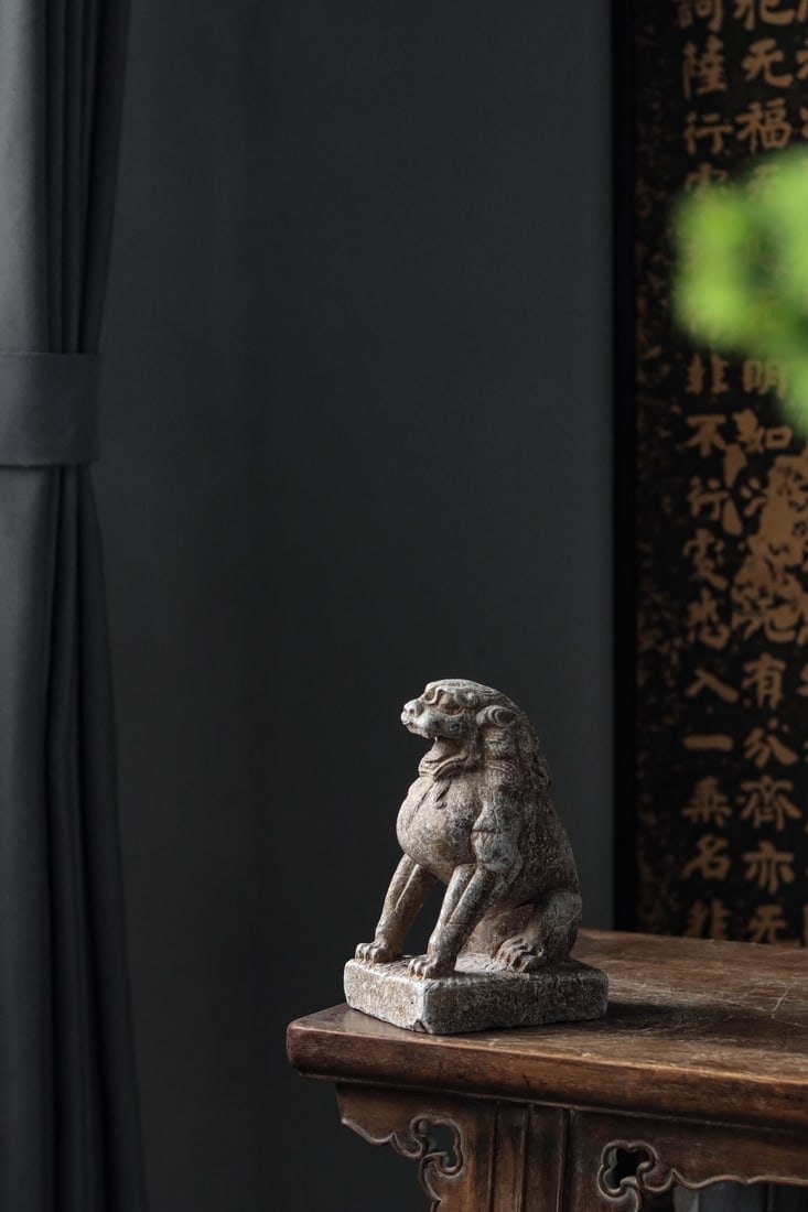 A CARVED STONE FOO DOG/LION, MING-QING DYNASTY: 7.87" x 3.94" x 4.72" (20cm x 10cm x 12cm)A fine Chinese carved stone Foo Dog (lion) from Ming-Qing Dynasty, seated on a square base, fierce expression, muscular limbs, superb craftsmanship, aged pati