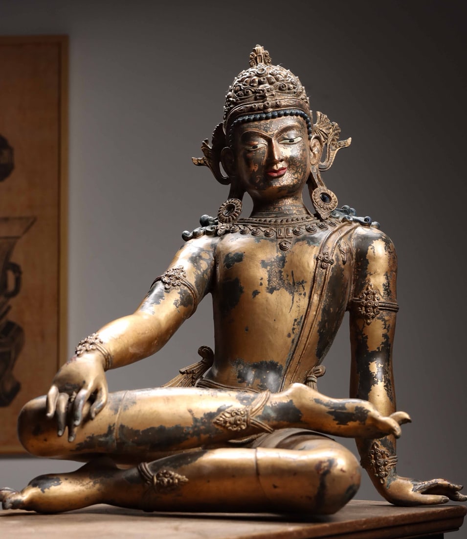 A GILT-BRONZE SEATED FIGURE OF GUANYIN (AVALOKITESHVARA), QING DYNASTY, TIBETAN STYLE: 24.41" x 21.65" x 14.96" (62cm x 55cm x 38cm) 45.86lb (20800g)A Qing Dynasty (1644-1912) Tibetan-style gilt-bronze Guanyin. Serene smiling face, elaborate jewelry, relaxed posture, natural patina. Fin