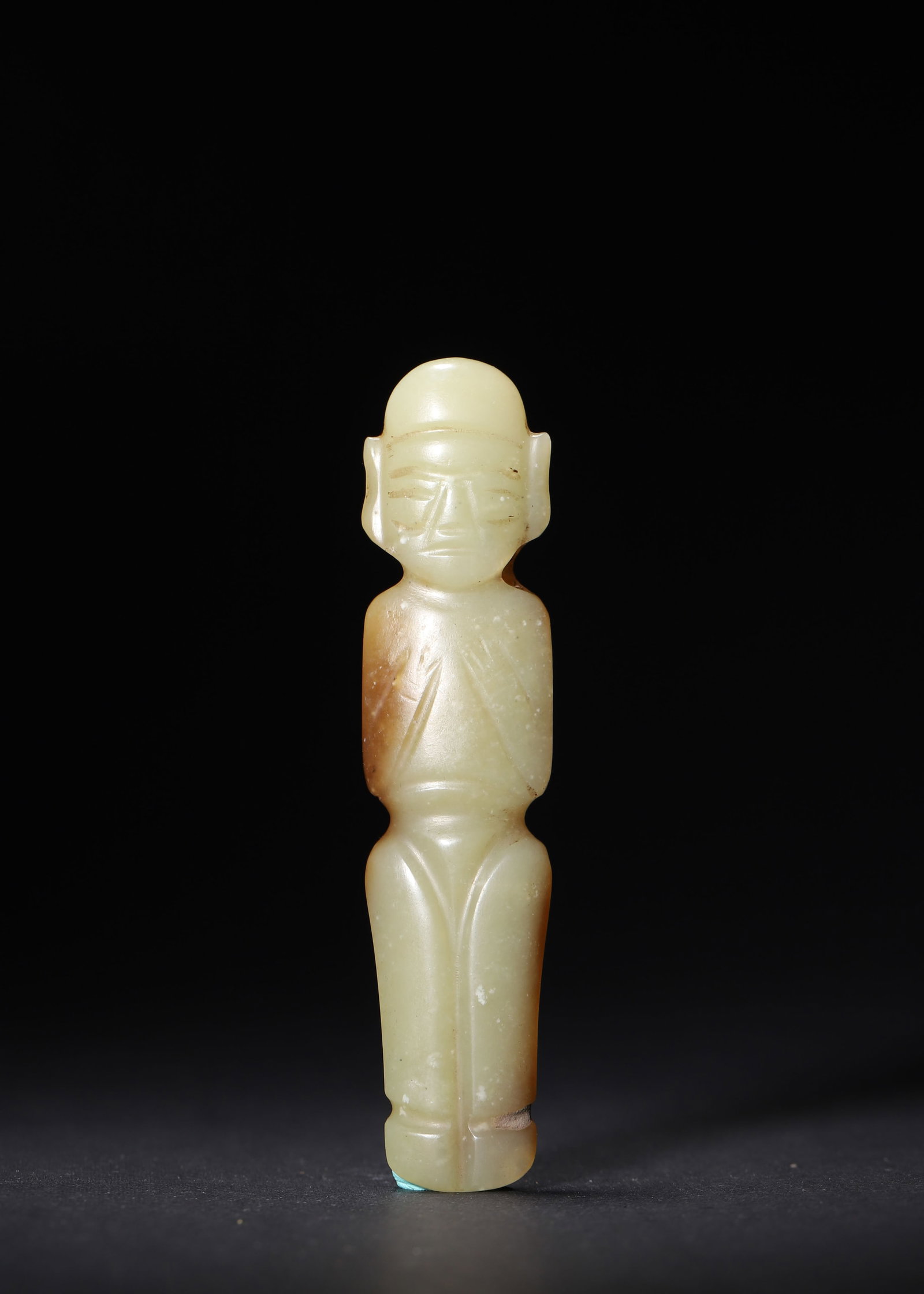 WESTERN ZHOU DYNASTY YELLOW JADE STANDING FIGURE PENDANT: 3.86in x 0.87in (9.8cm x 2.2cm) 0.077lbs (35g)A fine Western Zhou Dynasty yellow jade standing figure pendant, carved with hands clasped in a reverent pose. The warm russet patina, precise drilled hol