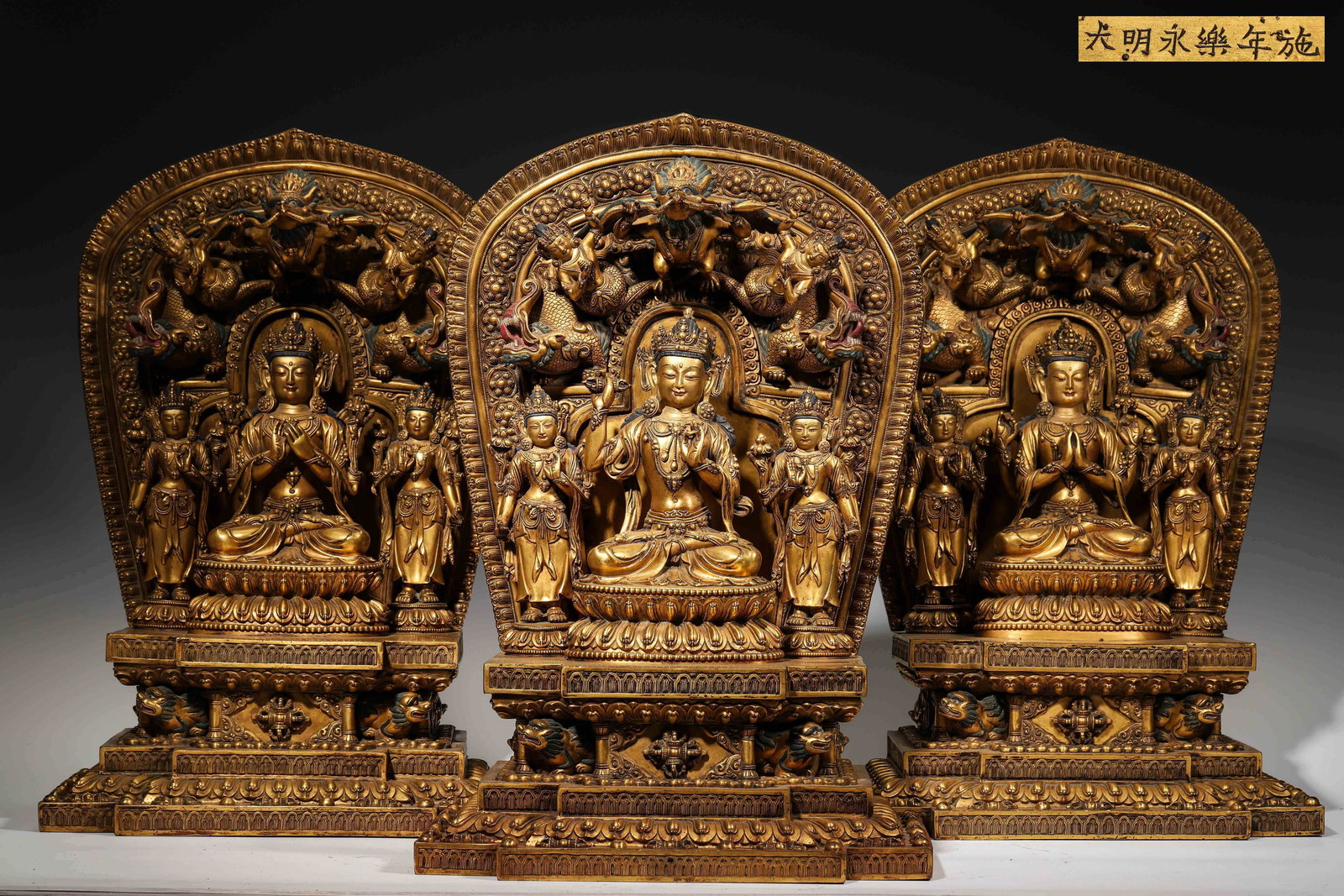 A SET OF THREE MAGNIFICENT GILT-BRONZE TRIRATNA BODHISATTVA STATUES, IMPERIAL WORKSHOP OF THE MING: L: 30cm (11.81in) W: 20cm (7.87in) H: 45cm (17.72in) Weight: 39kg (85.98lb)A rare set of three Ming Yongle imperial gilt-bronze Triratna Bodhisattva statues, inscribed with "Made in the Yongle Year of