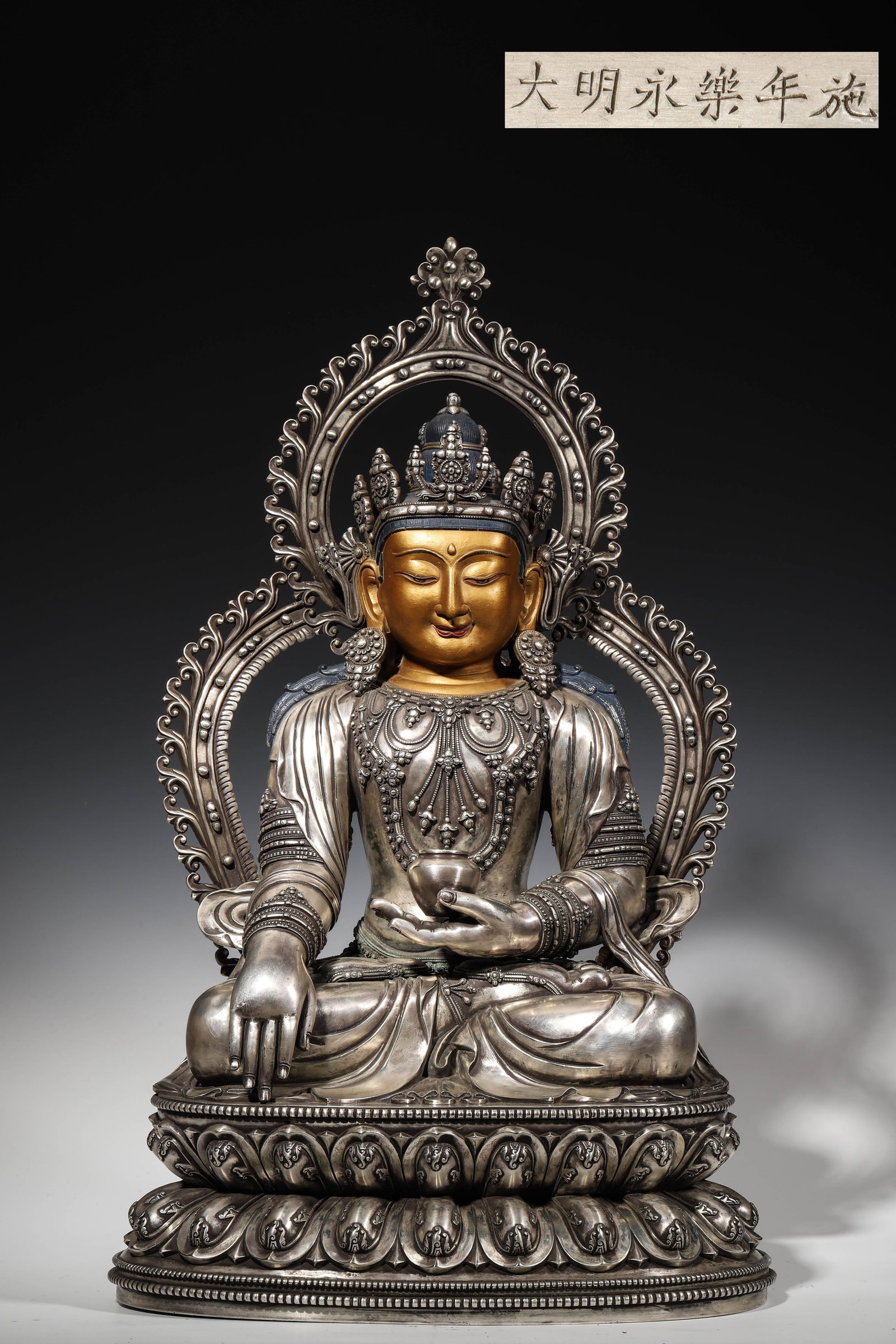A MAGNIFICENT SILVER STATUE OF AKSHOBHYA, IMPERIAL WORKSHOP OF THE MING YONGLE PERIOD: L: 30cm (11.81in) W: 20cm (7.87in) H: 52cm (20.47in) Weight: 12.4kg (27.34lb)A magnificent pure silver Akshobhya statue from the Ming Yongle imperial workshop, inscribed with "Made in the Yongle Year 