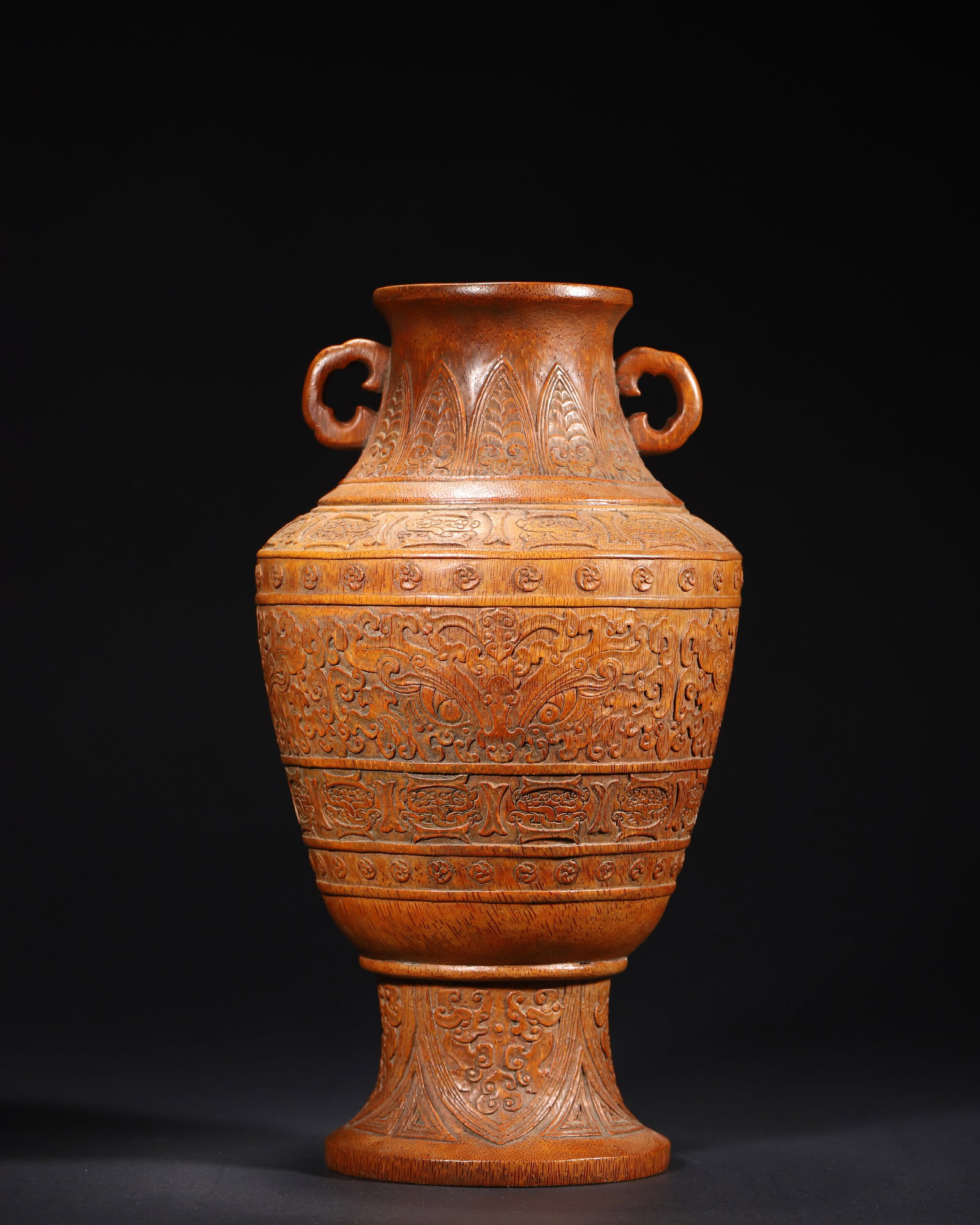 MID-QING DYNASTY, A BAMBOO CARVED DOUBLE-EARED VASE WITH ARCHAIC TAOTIE PATTERN: 6.69in x 11.81in (17.0cm x 30.0cm), 3.038lb (1378.0g)This Mid-Qing bamboo vase, modeled after Shang-Zhou bronze vessel, features double ruyi ears and archaic taotie patterns. Carved with banana leaf, 