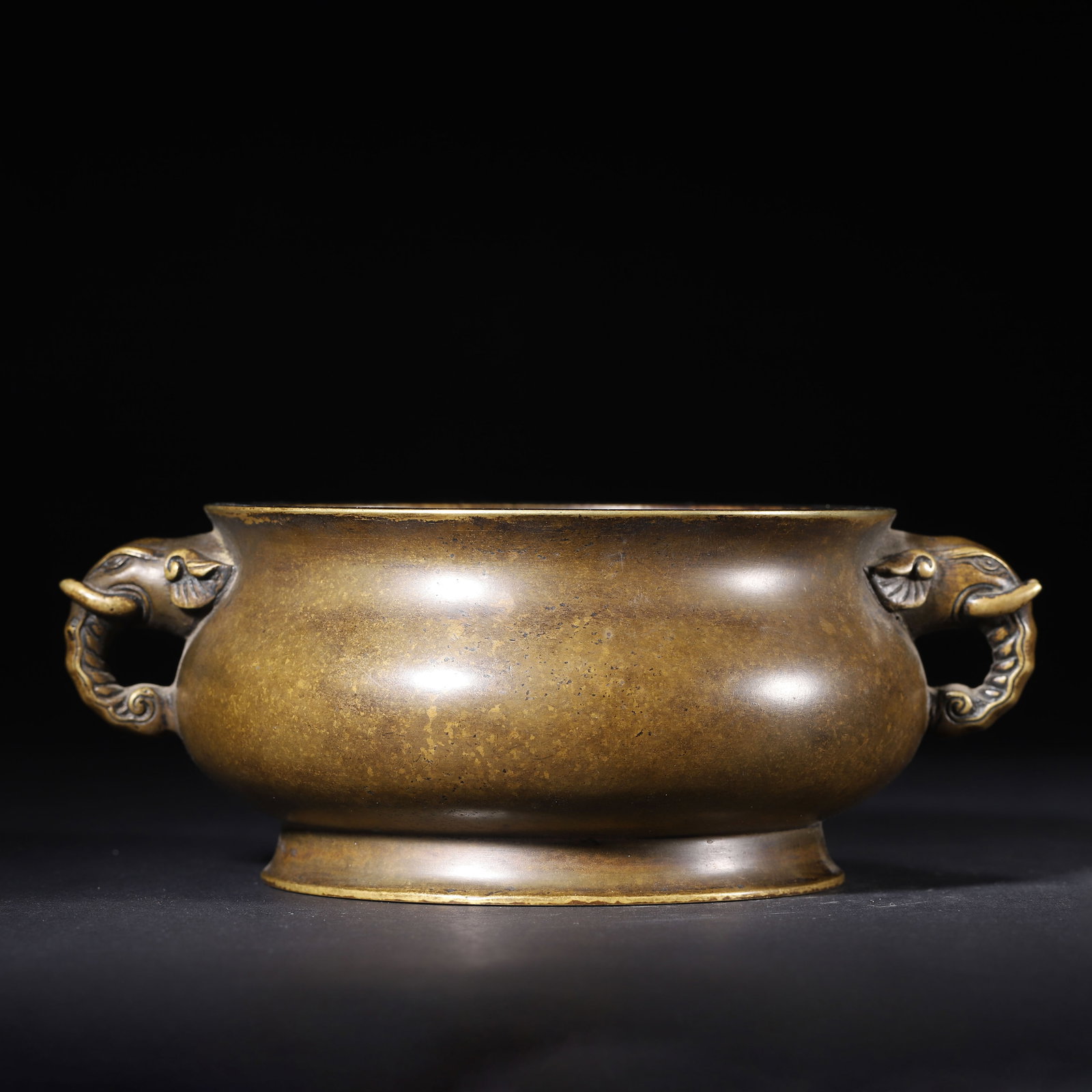 QING DYNASTY BRONZE CENSER WITH ELEPHANT HANDLES: 7.09" x 2.76" (18.0cm x 7.0cm) 3.111lb (1411g)An elegant Qing Dynasty bronze censer, modeled after Ming Xuande prototypes. It features finely carved elephant-head handles symbolizing peace, and a rich