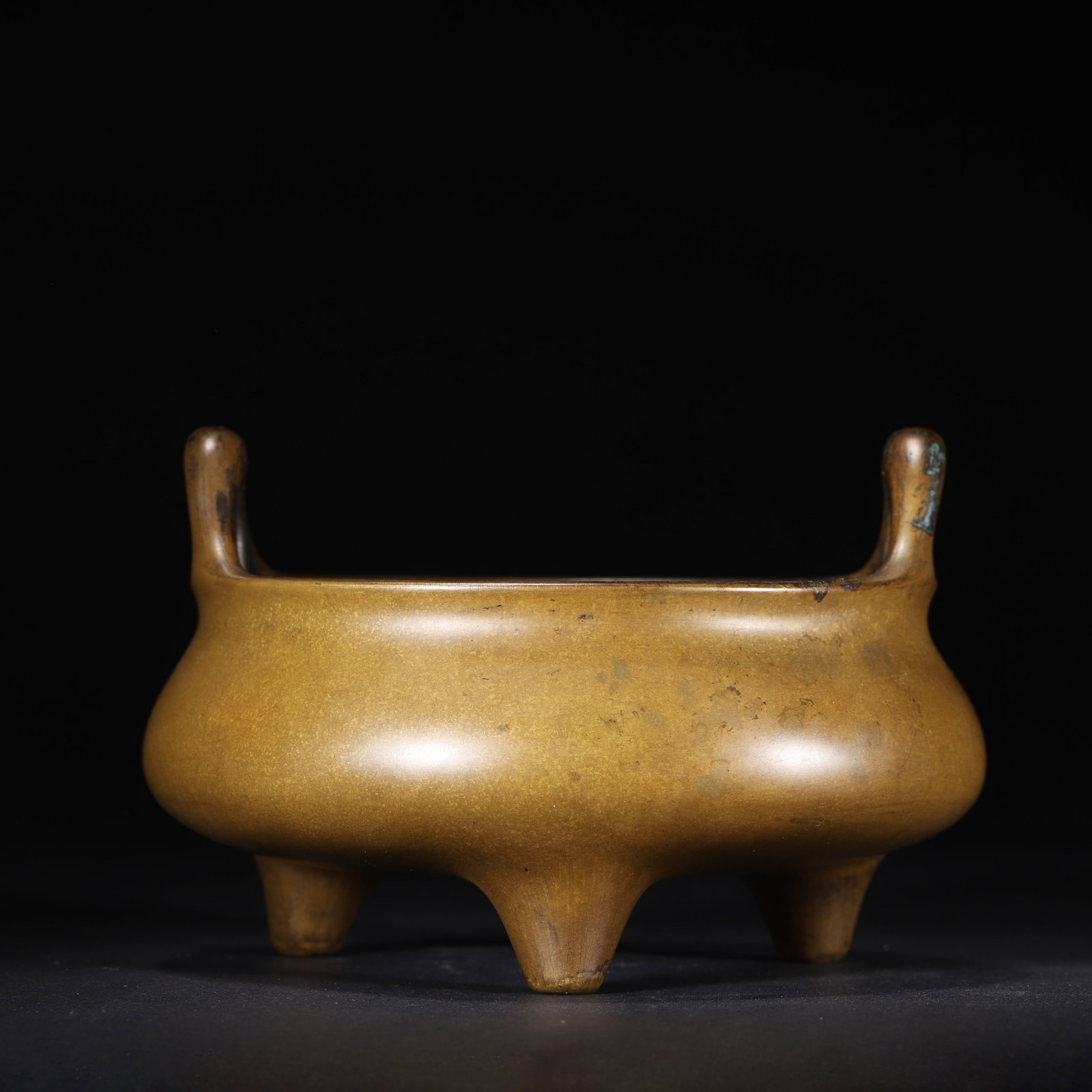QING DYNASTY BRONZE TRIPOD CENSER WITH BRIDGE HANDLES, JI FAMILY COLLECTION MARK: 6.3" x 3.94" (16.0cm x 10.0cm) 2.723lb (1235g)This refined Qing Dynasty bronze censer, bearing the "Ji Family Collection" mark, follows Ming Xuande prototypes. It features elegant bridge handles and a
