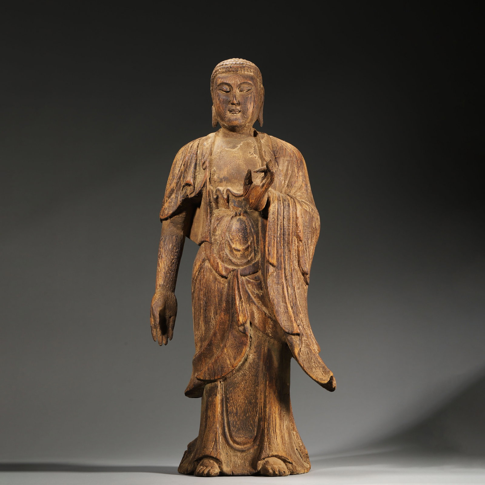 A MAGNIFICENT CARVED WOOD STANDING SHAKYAMUNI BUDDHA STATUE, MING DYNASTY (15TH-17TH CENTURY): L: 20cm (7.87in) W: 14cm (5.51in) H: 45cm (17.72in) Weight: 1041g (2.29lb)A magnificent 15th-17th century Ming Dynasty carved wood standing Shakyamuni Buddha statue, exquisitely crafted with a serene 