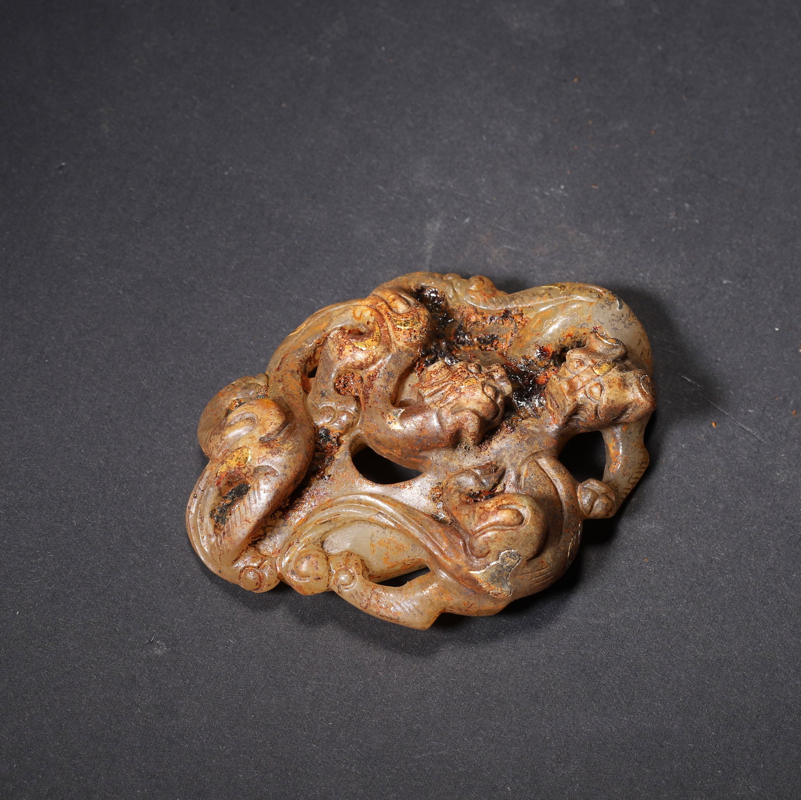 HAN DYNASTY GOLD-INLAID JADE DOUBLE-CHI DRAGON HEART PENDANT: 2.76" x 1.57" (7.0cm x 4.0cm) 0.168lb (76g)Carved from Hetian jade, this Han Dynasty pendant features two intertwined Chi dragons in openwork with residual gold inlay. Its central hole and natural soi