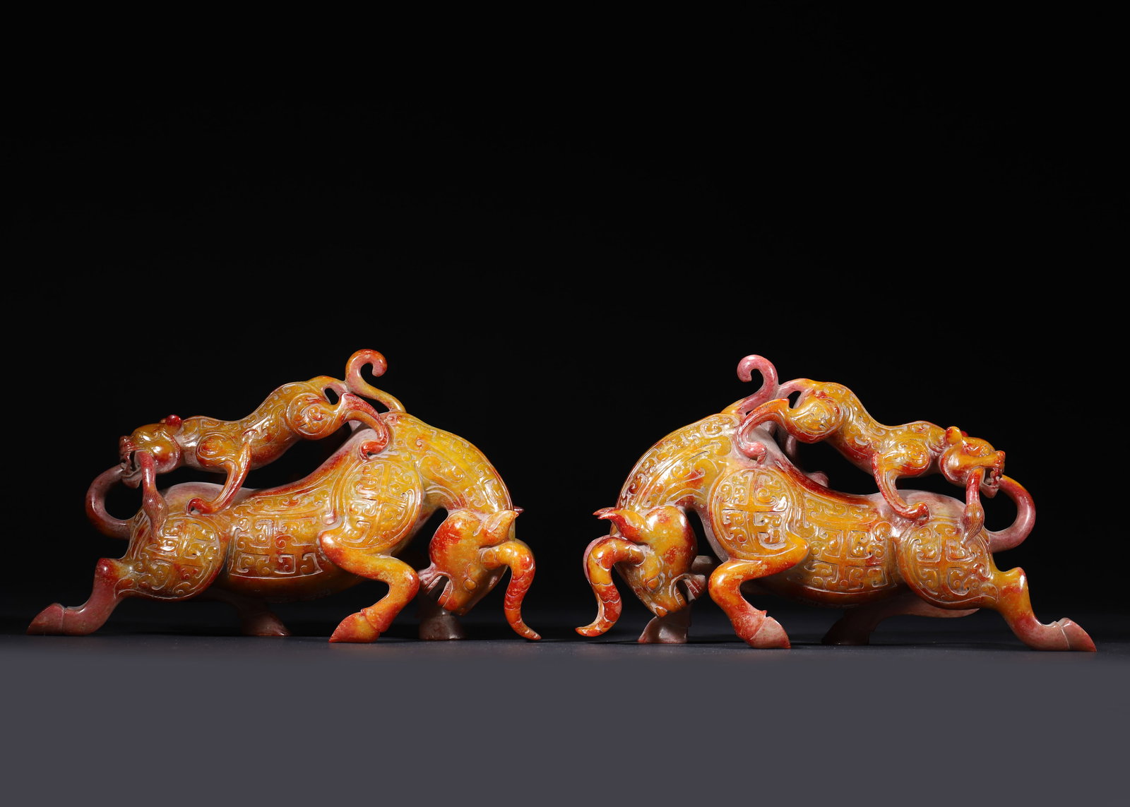 PAIR OF HAN DYNASTY HETIAN JADE TIGER-OX FIGURINES WITH CINNABAR PATINA (1 of 14)