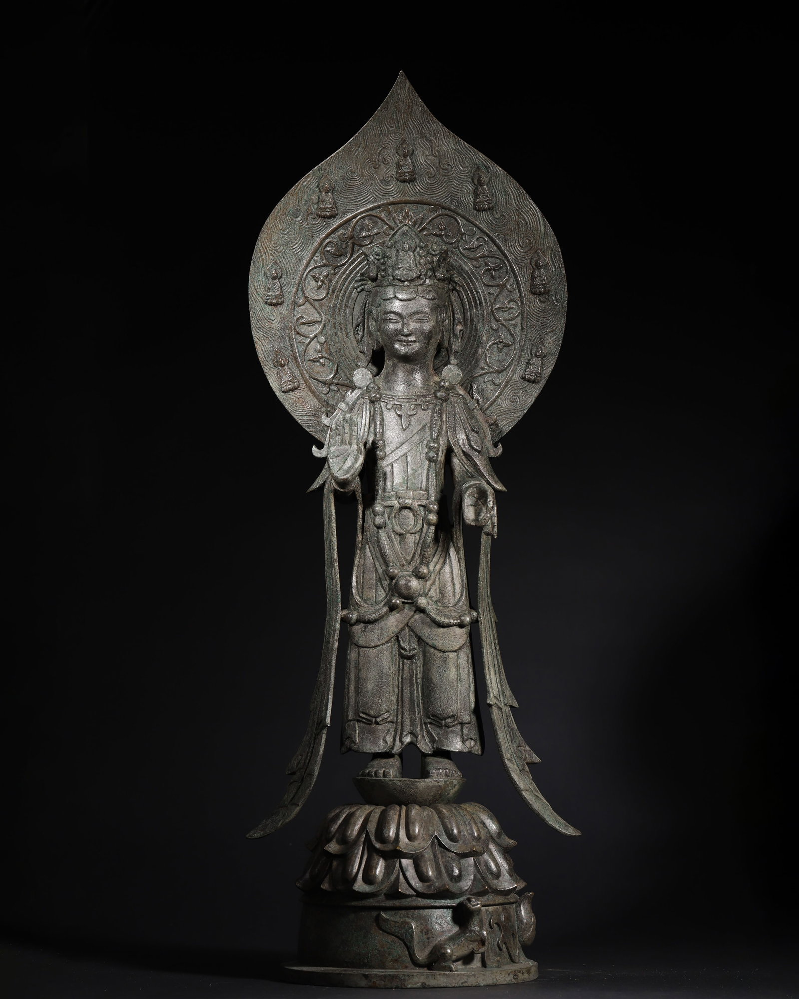SUI DYNASTY BRONZE STANDING STATUE OF GUANYIN BODHISATTVA WITH HALO AND MYTHICAL BEAST BASE: 9.84in x 7.09in x 28.35in (25.0cm x 18.0cm x 72.0cm), 17.798lb (8073.0g)This Sui Dynasty bronze Guanyin stands elegantly, adorned with a crown, necklaces, and flowing robes. Its boat-shaped halo and m