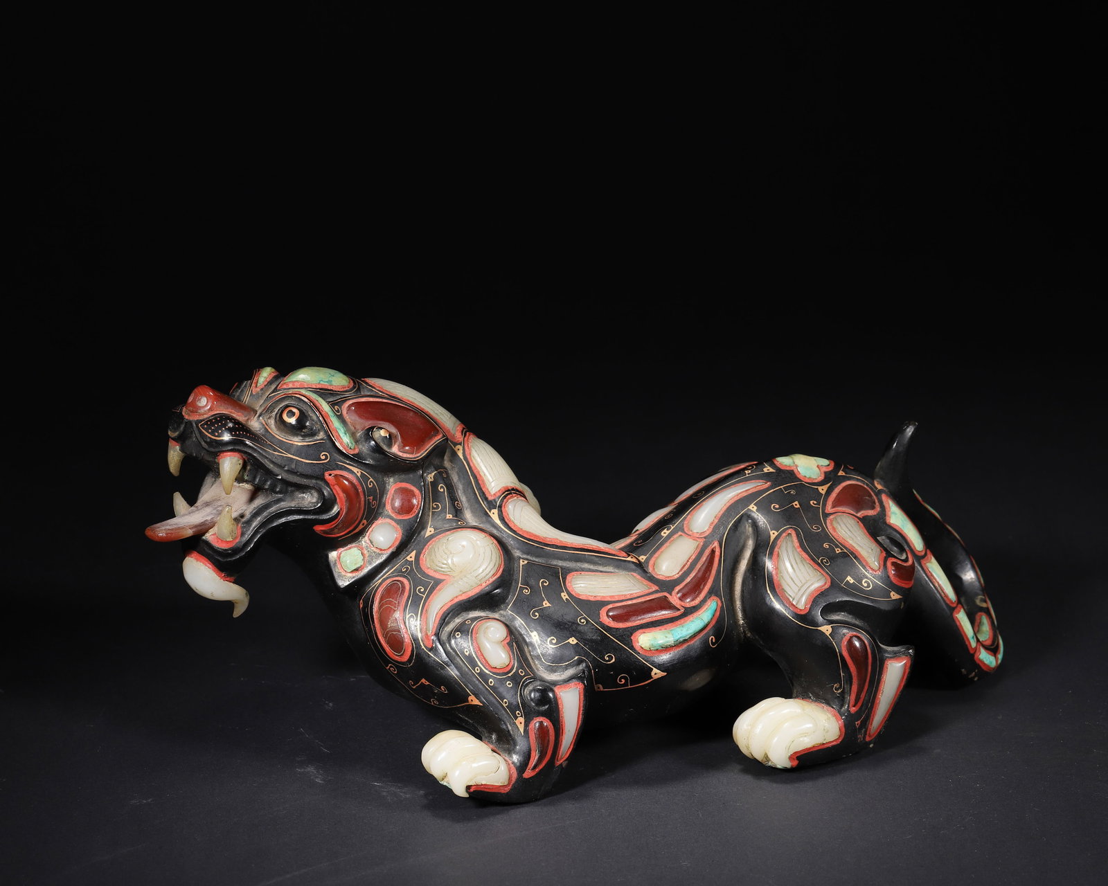 A CHINESE HAN DYNASTY HETIAN JADE PAINTED MYTHICAL BEAST (TIANLU) INLAID WITH GEMS: 12.6in x 7.48in x 5.12in (32.0cm x 19.0cm x 13.0cm), 6.296lb (2856.0g)A magnificent Han Dynasty Tianlu carving, carved from Hetian jade, painted and inlaid with agate and turquoise. A masterpiece of H