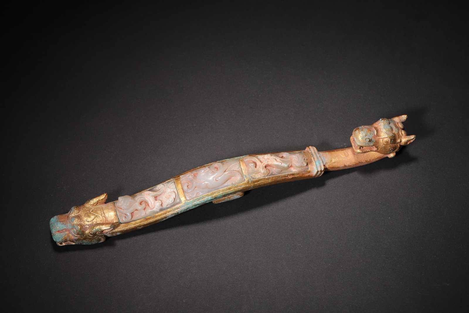 A FINE WARRING STATES TO HAN DYNASTY GILT-BRONZE BELT HOOK INSET WITH WHITE JADE AND DOUBLE BEAST: 8.66in (22.0cm), 0.844lb (383.0g)This Warring States to Han Dynasty gilt-bronze belt hook features double beast heads and inlaid white jade 'Chi' dragon carvings. The harmonious gold-jade combination 