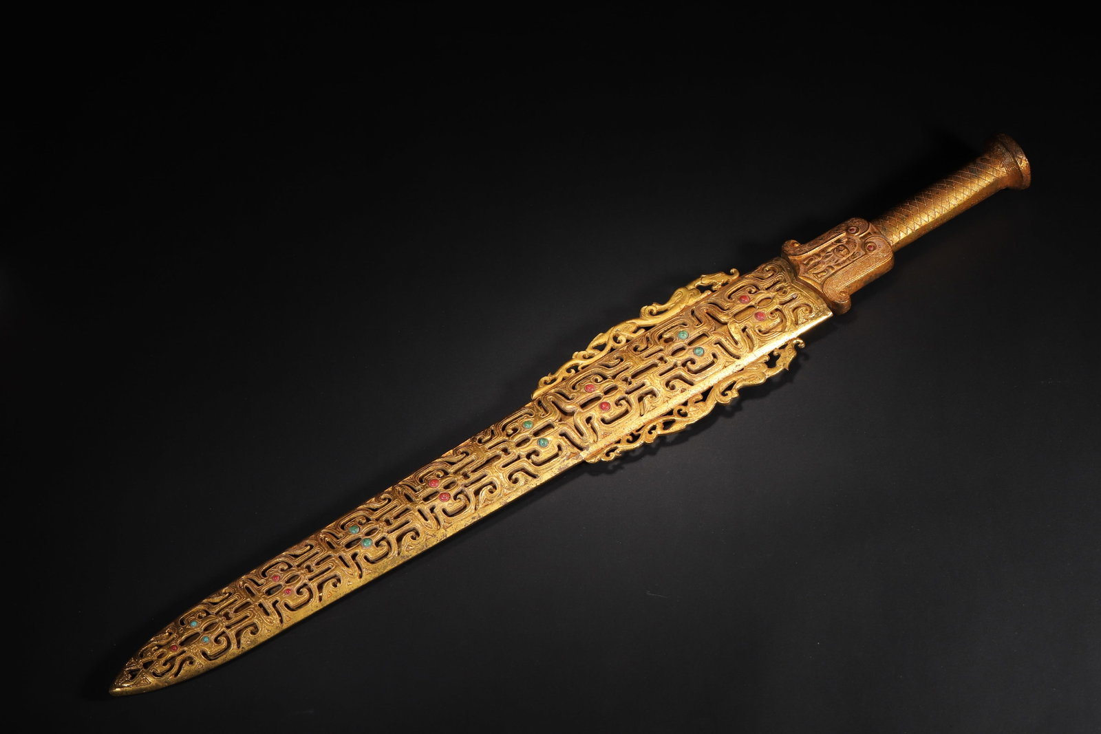 A FINE WARRING STATES TO HAN DYNASTY GILT-BRONZE ORNAMENT WITH TURQUOISE AND AGATE INLAY (WITH: 18.9in x 2.76in (48.0cm x 7.0cm), 2.116lb (960.0g)This Warring States to Han Dynasty gilt-bronze ornament and scabbard feature intricate openwork dragon patterns and gem inlay. Gilded throughout, it r