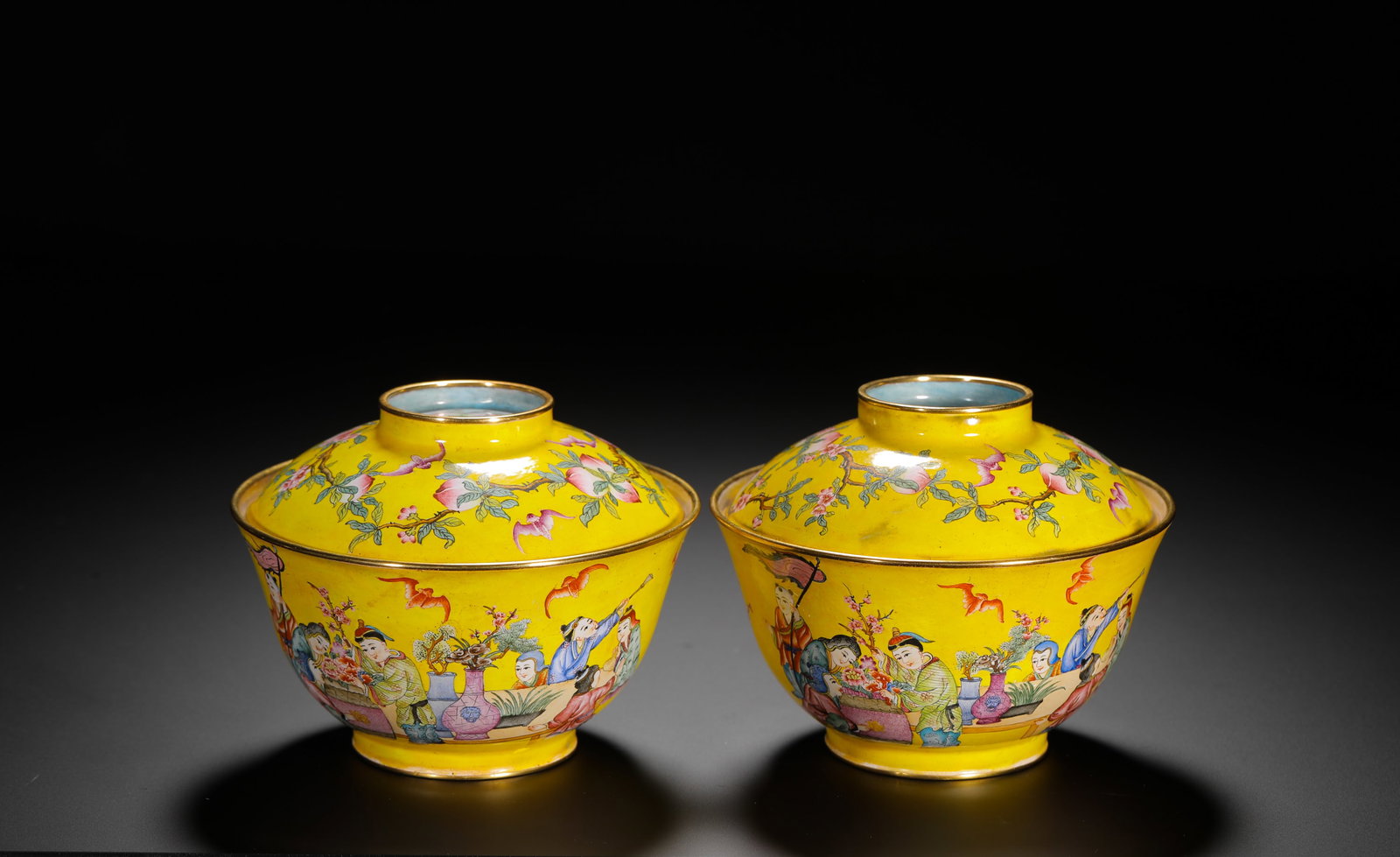 Qing Dynasty Pair of Enamel Covered Tea Bowls with Children on Yellow Background: These Qing Dynasty imperial copper-glazed painted enamel covered bowls are an impressive pair. Both bowls and covers are finished in a bright yellow background. The bowl foreground depict children at 