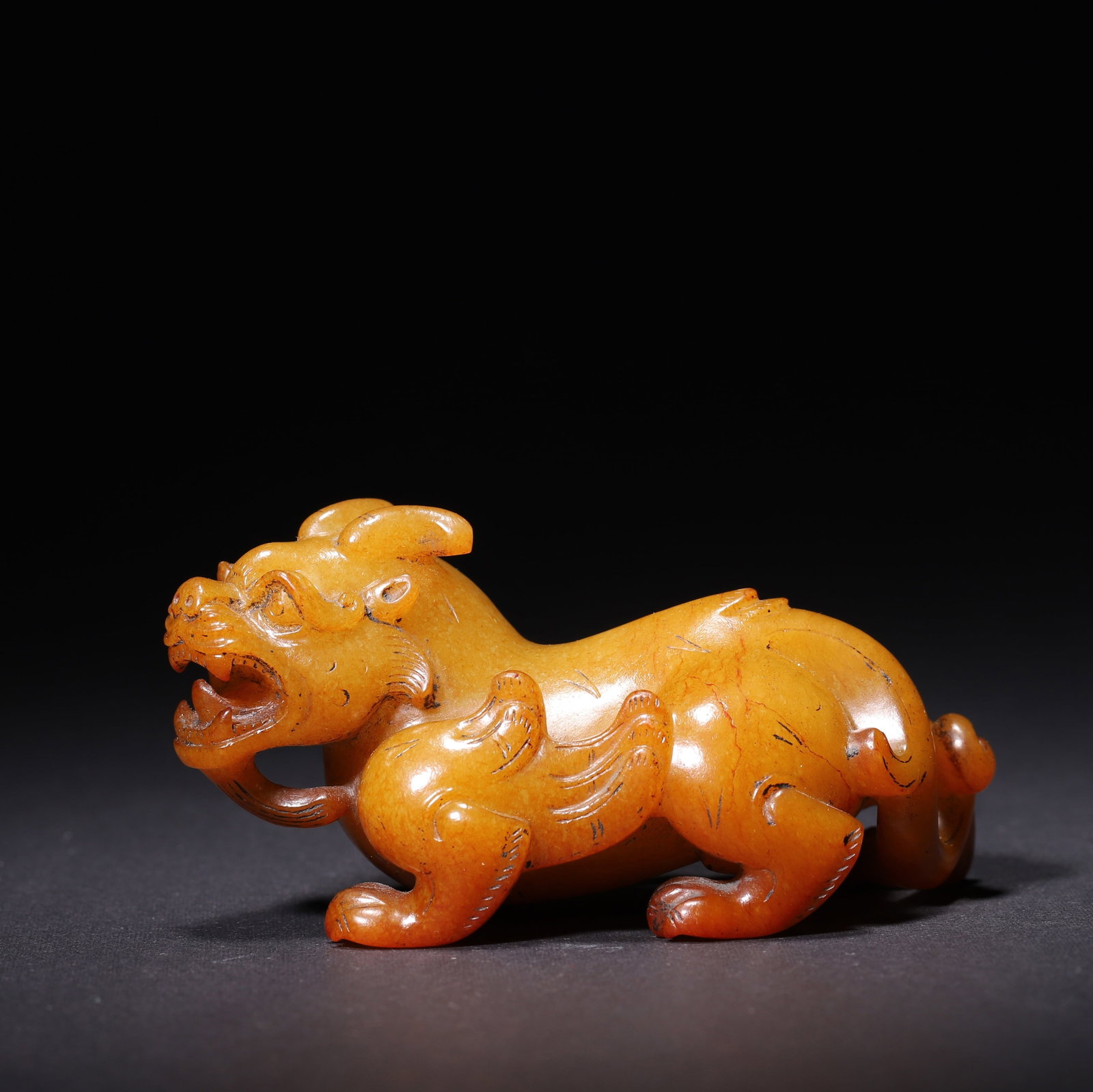 Yellow Jade Bixie Creeping Pose Beast Ornament, Han Dynasty: A Han dynasty yellow nephrite jade bixie beast ornament, carved in a creeping pose with a fierce expression and spreading wings on the shoulders. The surface features crisp archaic incised lines, whil