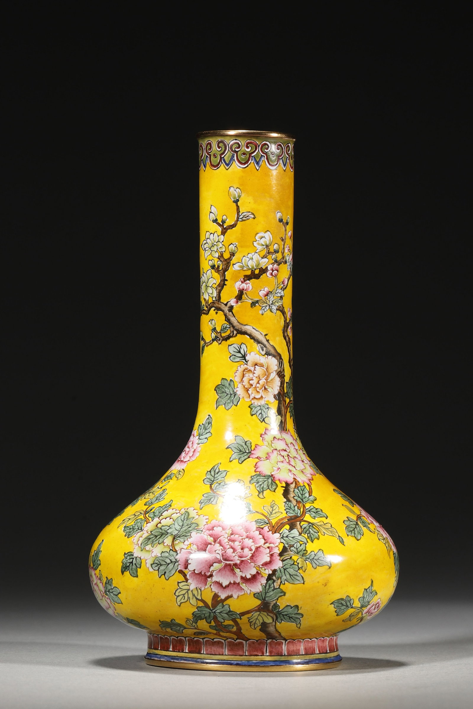 Miniature Enamelled Copper Vase with Peony Motifs, Qianlong Period: A miniature enamelled copper vase, Qianlong period, decorated with elegant peony blossoms on a yellow ground, framed by gilt rims and bearing a Qianlong mark. The vibrant floral design and luxurious e