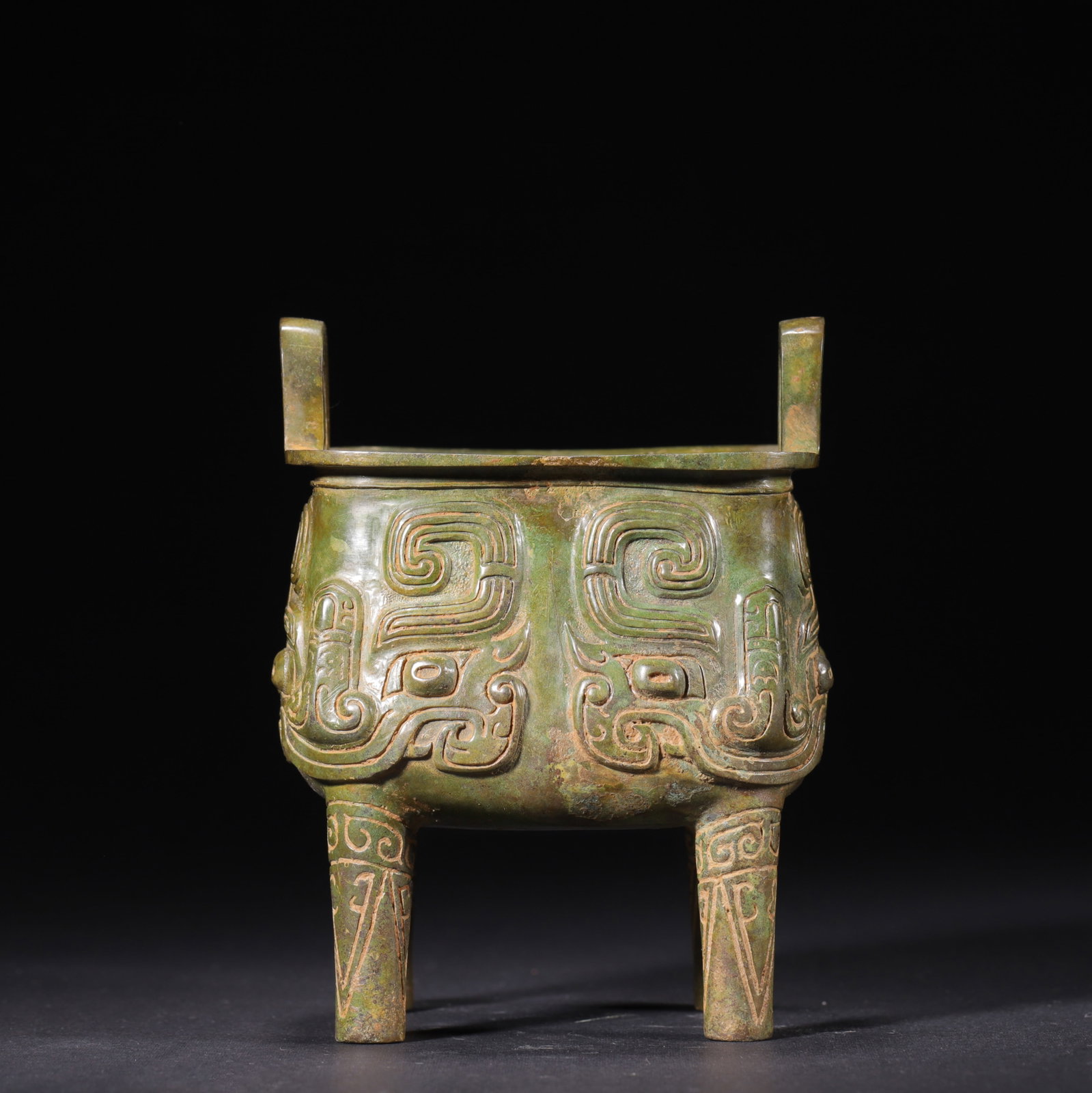 Western Zhou Dynasty Square Bronze Ding with Raised Beast Mask Reliefs: This Western Zhou dynasty square bronze ritual ding features square upright handles and four decorated legs, with all sides adorned in fully raised taotie beast mask reliefs and spiraling cloud motifs