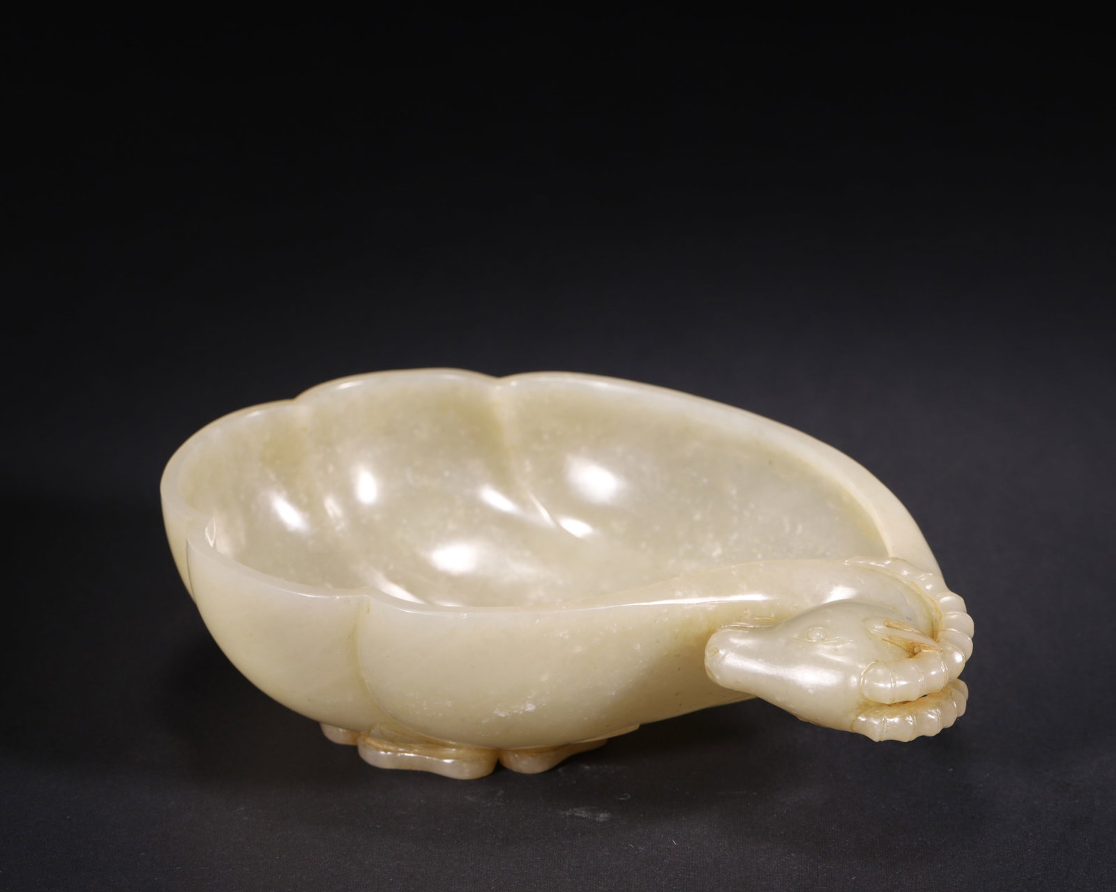 Qing Dynasty, Celadon Hetian Jade Brush Washer with Ram Head and Floral Patterns: Carved from a single block of celadon Hetian jade, this Qing dynasty leaf-shaped brush washer features a delicately modeled ram head at one end, with relief floral carvings along the exterior and leaf
