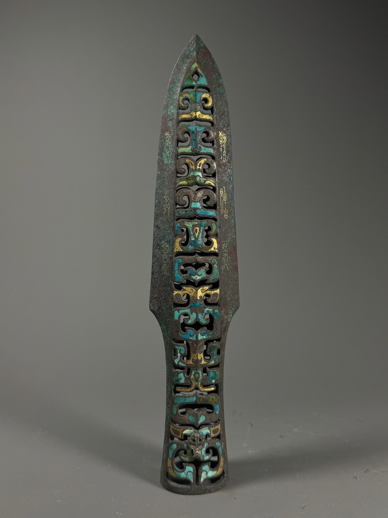 WARRING STATES PERIOD, BRONZE SPEAR WITH GOLD INLAID WITH TURQUOISE: Warring States Bronze Spear with Openwork, Gold Inlay and Turquoise Inlay. The spear blade features openwork interwoven chilong patterns inlaid with turquoise and outlined with gold. Vertical