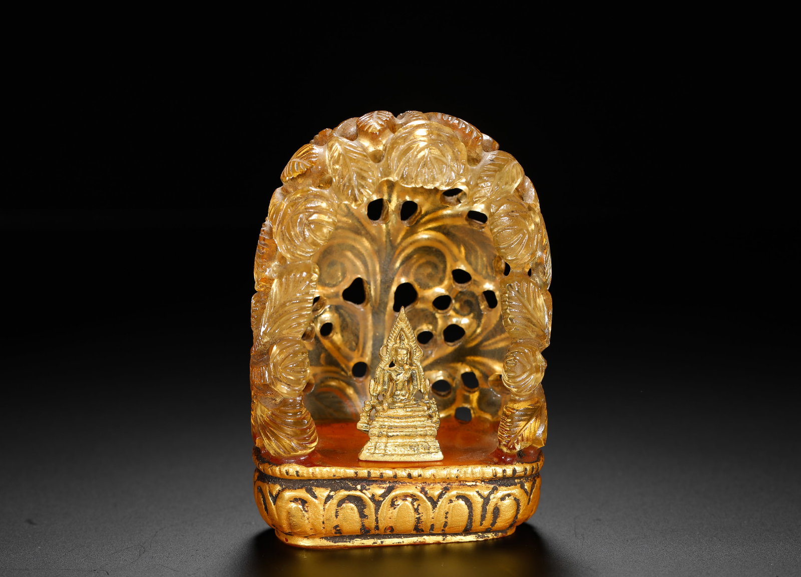 A GILDED SMALL BUDDHA STATUE IN A CRYSTAL THROUGH-CARVED FLOWER AND LEAF NICHE