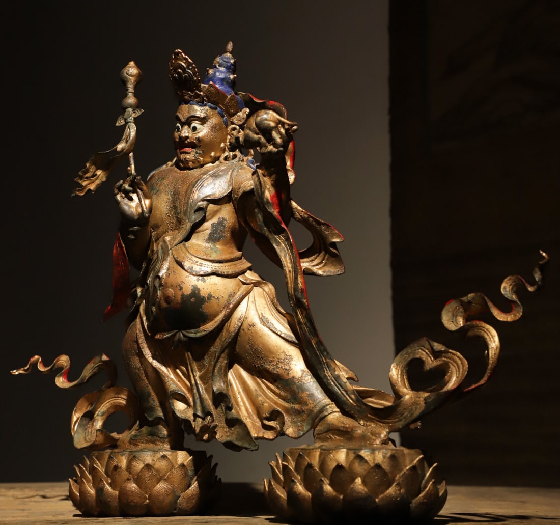 QING DYNASTY, GILDED BRONZE STATUE OF KING GESAR: Cast in fine bronze with partial worn gilding, vermilion pigment preserved on lips. Wearing Tibetan heroic hat and intricately patterned Tibetan robe adorned with floral necklaces. Seated in relaxed p