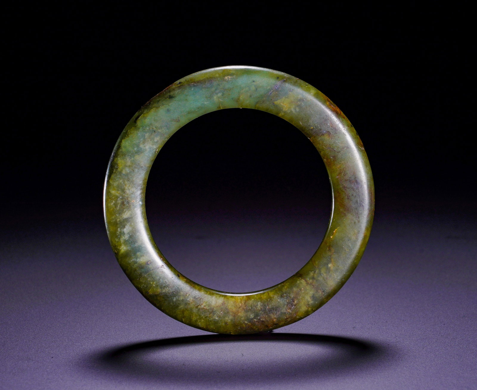HAN DYNASTY JADE RINGS: The round artifact is a vital component of Han composite jade pendants. The jade is suffused by interwoven green and brown ancient patina. Circular jade rings symbolize completeness and were threaded 