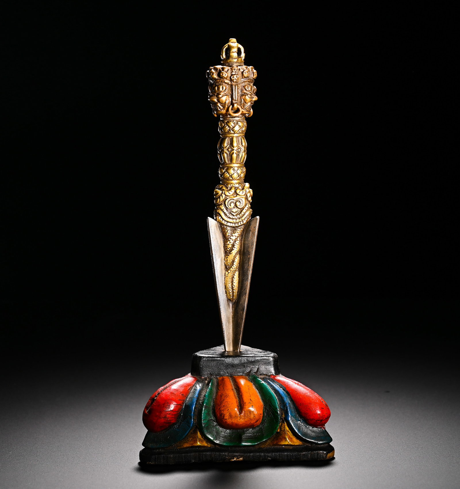 QING DYNASTY, GILDED BRONZE SCEPTER: Dimensionswith Qing Dynasty gilt copper phurba vajra, equipped with painted wooden lotus base. Phurba, also known as the dagger of subduing demons, is carved with three wrathful beast faces at the top