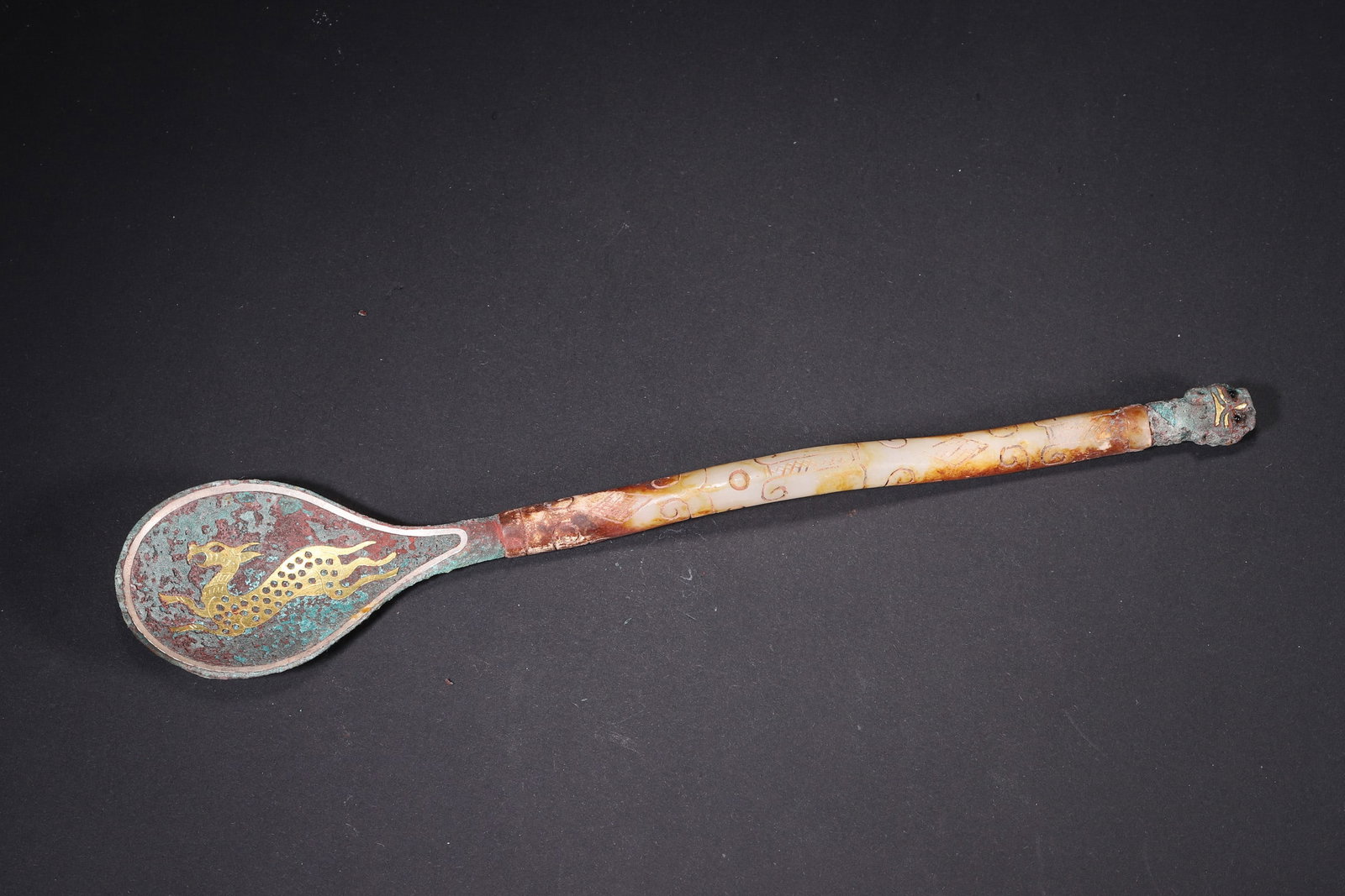 Warring States Period, Bronze Spoon with Gold-Silver Inlay and Jade Handle: This Warring States bronze spoon features a jade handle with cloud patterns and exquisite gold and silver inlay with a deer motif. It embodies the superb craftsmanship and noble aesthetic of the Warri