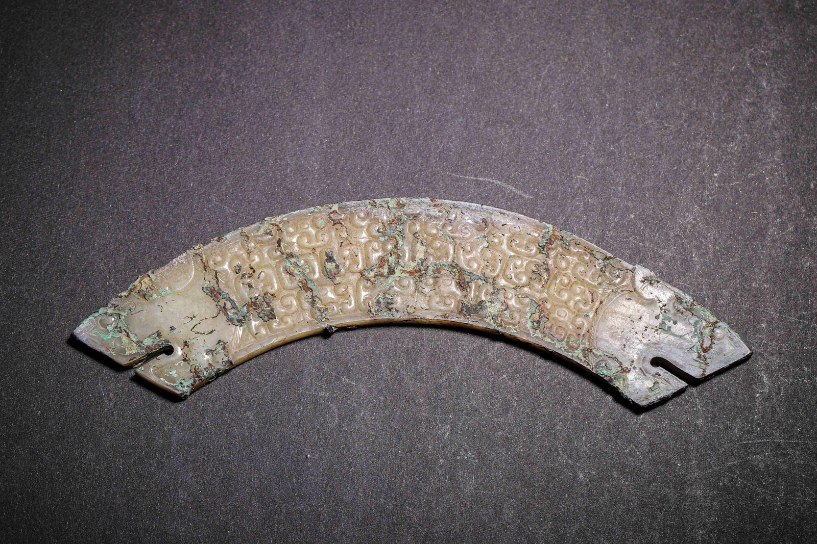 Hetian Jade Double-Dragon-Head Huang with Serpent Pattern, Warring States (475-221 BC): Hetian jade, arc-shaped huang. Dragon heads at both ends, fully carved serpent patterns on both sides. Covered with copper-green patina, typical pendant of Warring States period. Dimensions: Length: 1