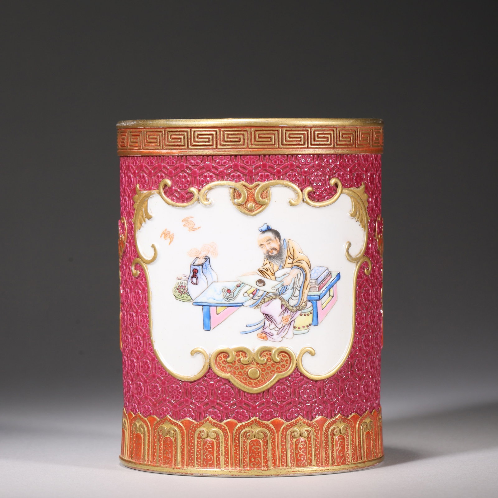 Qing Dynasty, Qianlong Period, Carved Gilt Brush Pot with Famille Rose Literati Panels: Qianlong marked cylindrical brush pot. Carved crimson ground with gilt ruyi frames, painted famille rose literati scenes with antiques and bats. Turquoise glazed interior and base, red six-character Q