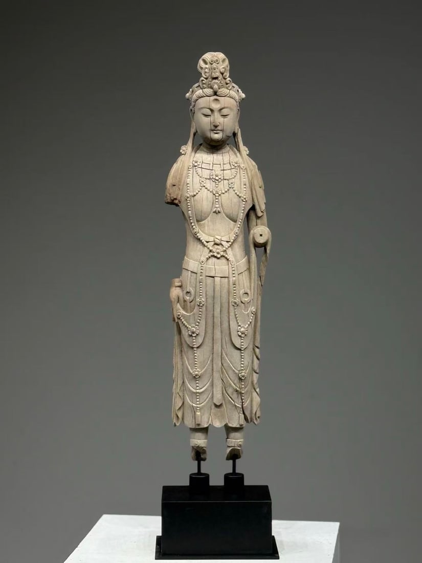 Song Dynasty, Fine Carved Wood Standing Bodhisattva: The Guanyin wears a tall crown, atop which sits a miniature Buddha (a transformed Buddha). With delicate eyebrows, elegant eyes, and full cheeks, one glance at her serene countenance dispels all