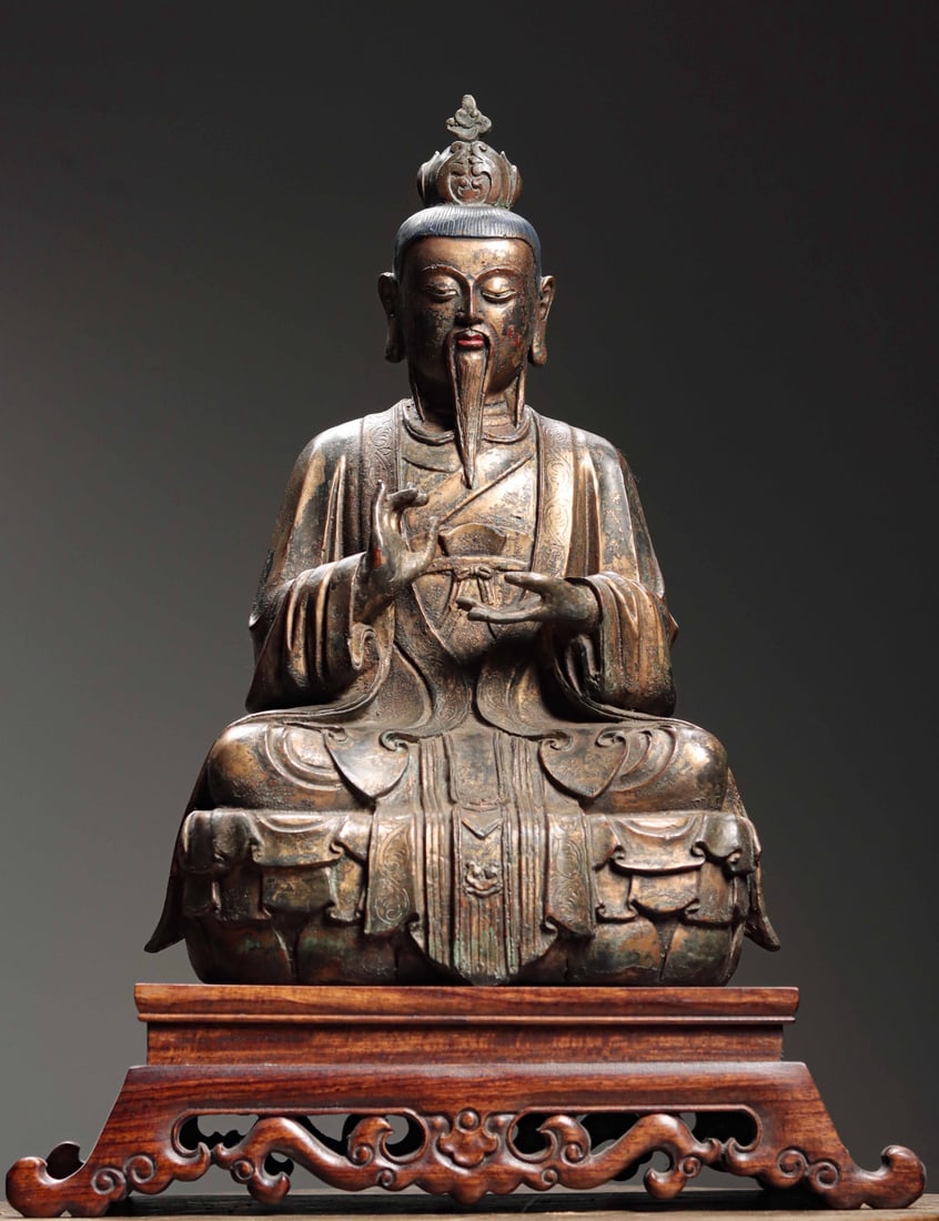 Ming Dynasty, Gilt-Bronze Seated Figure of Taishang Laojun: With a kind face and lowered eyes, it exudes wisdom and peace. Slightly upturned lips convey calmness. Clad in a long robe with natural, smooth, exquisitely carved folds, seated in full lotus