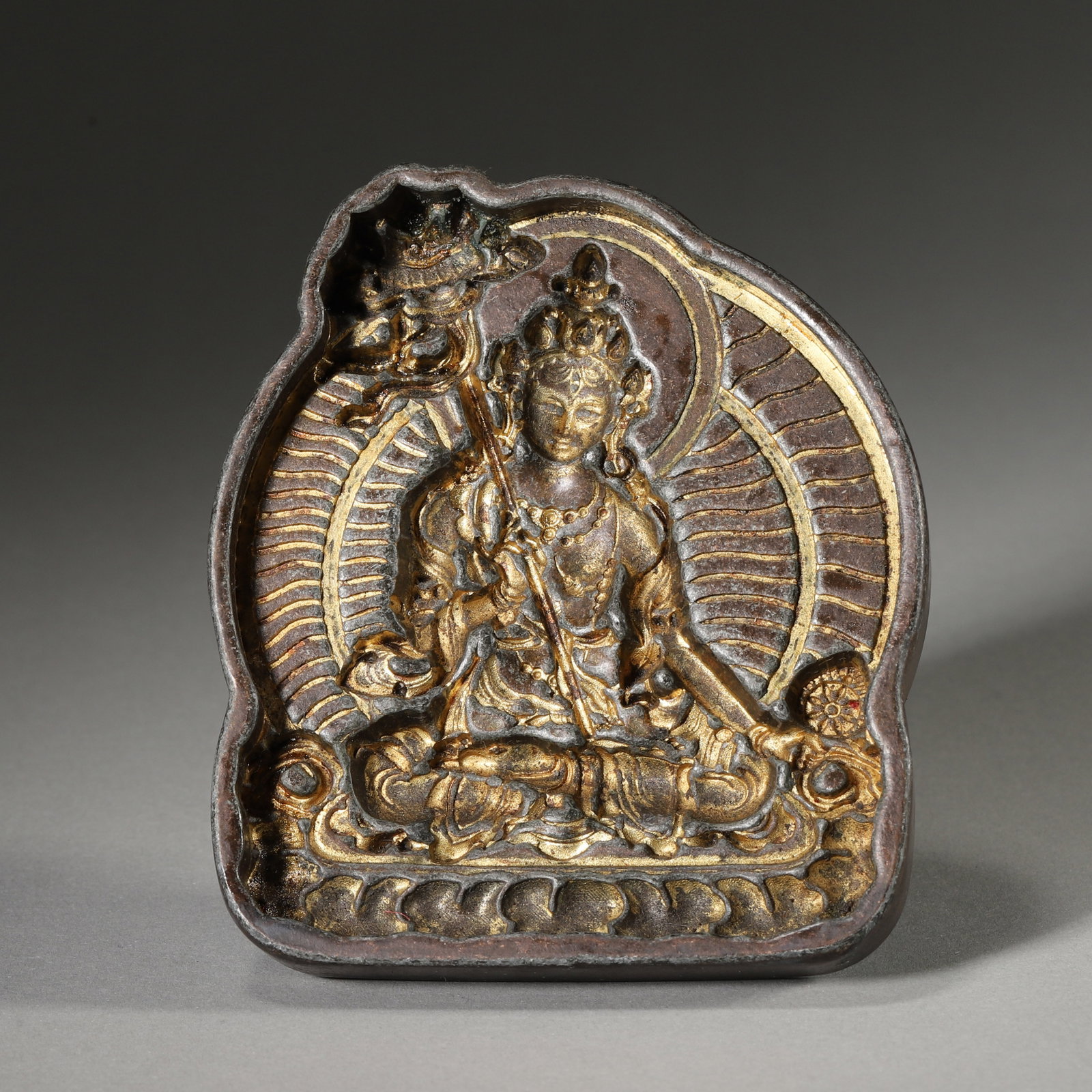 Gilt-Bronze White Umbrella Goddess Tsa-Tsa Mold, Qing Dynasty, 1636-1912: Bronze mold with gilded interior. Flower-shaped cavity,Goddess seated on lotus base with halo.A handle on reverse,used for producing tsa-tsa. Dimensions: Diameter: 4cm (1.57in), Height: 9.5cm