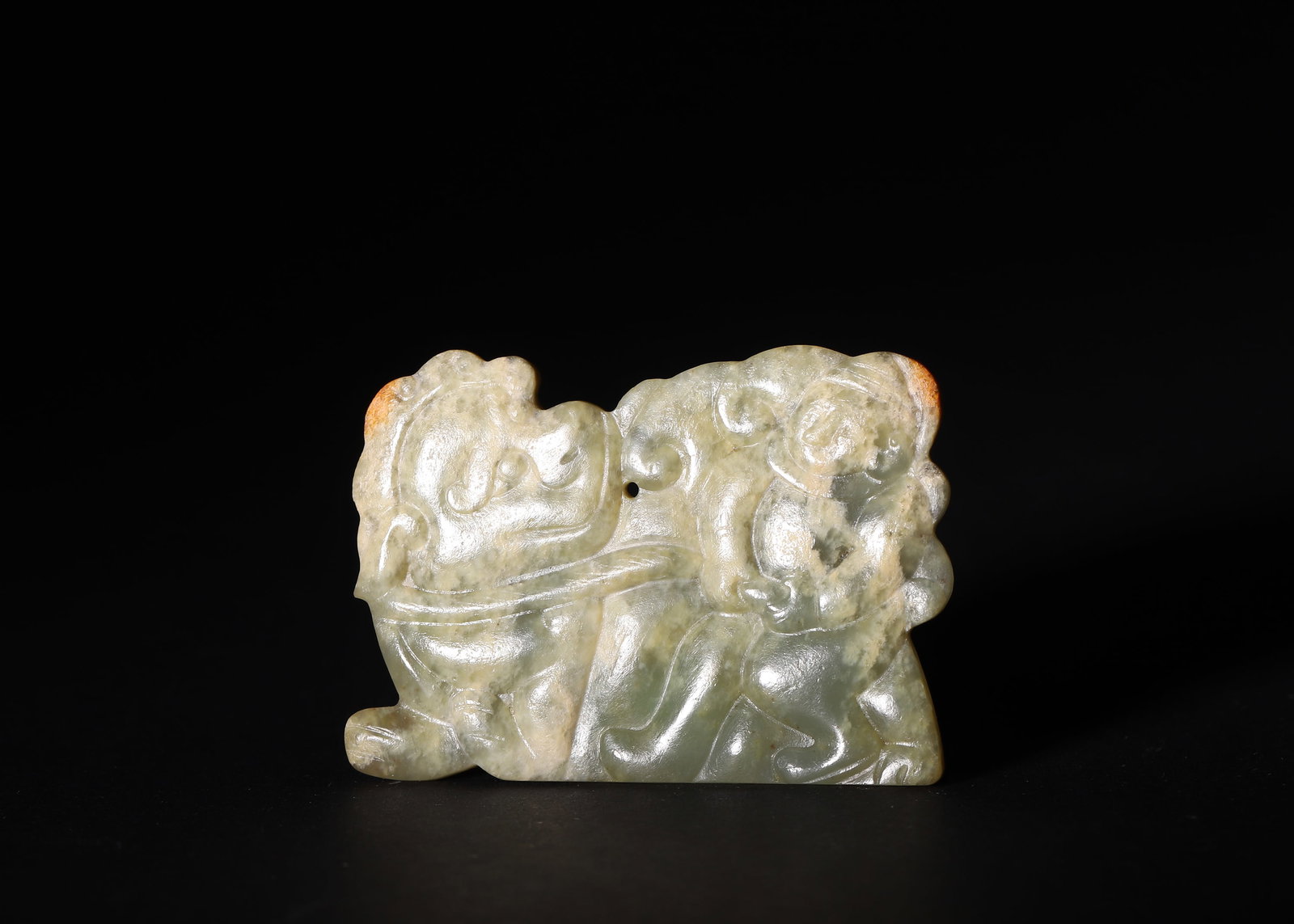 Han Dynasty, Celadon Jade Pendant with Immortal Taming Beast Motif: A carved celadon jade plaque pendant of Han Dynasty. Front relief carved scene of immortal taming auspicious beast, single suspension hole at center. Natural russet skin reserved at two ends, cloud-li