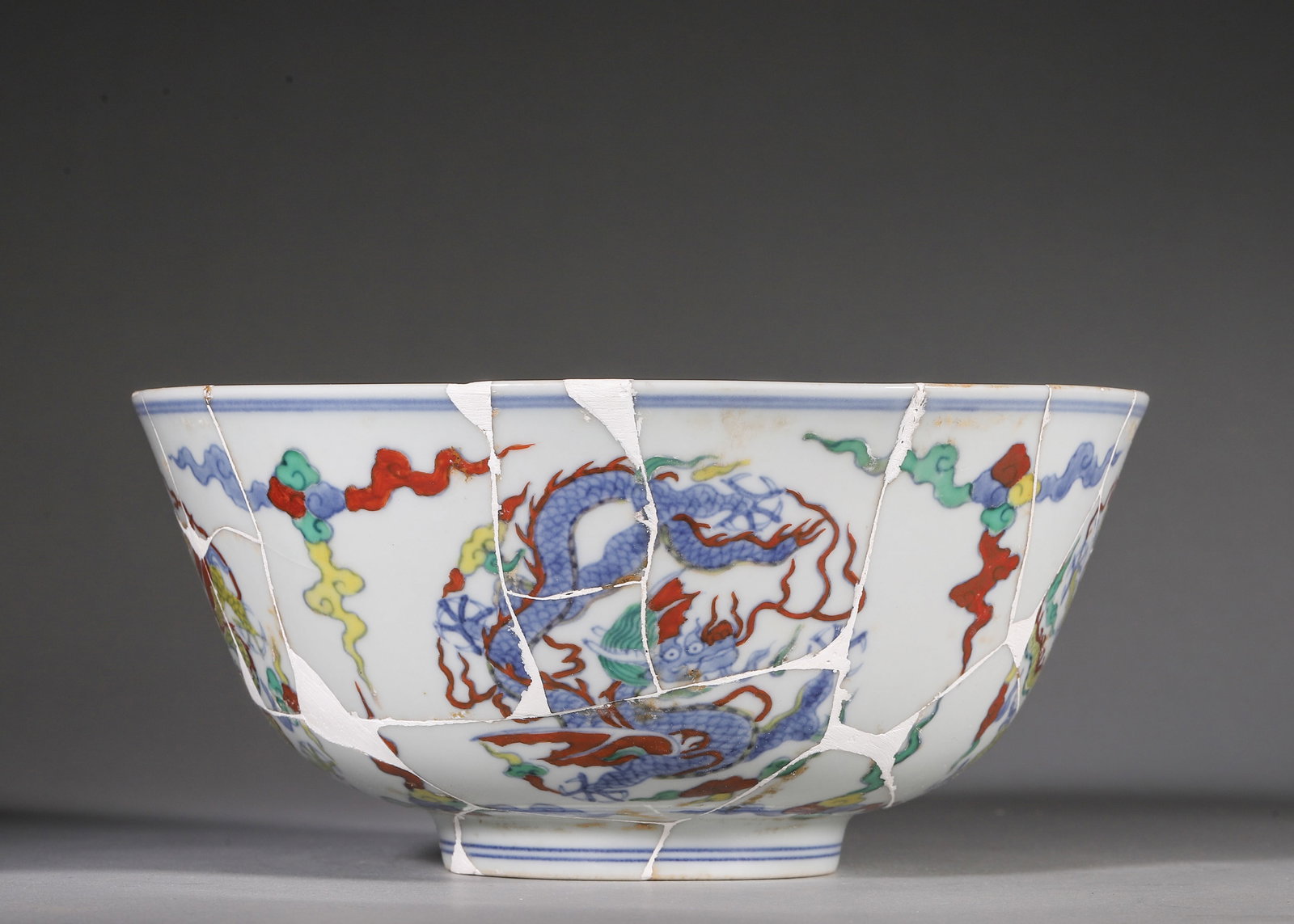 Ming Dynasty, Doucai Dragon Bowl, Chenghua Period: Ming Chenghua mark and period. Wide-mouthed porcelain bowl with square six-character reign mark on base. Interior and exterior decorated with round dragon medallions amid colorful cloud scrolls in dou
