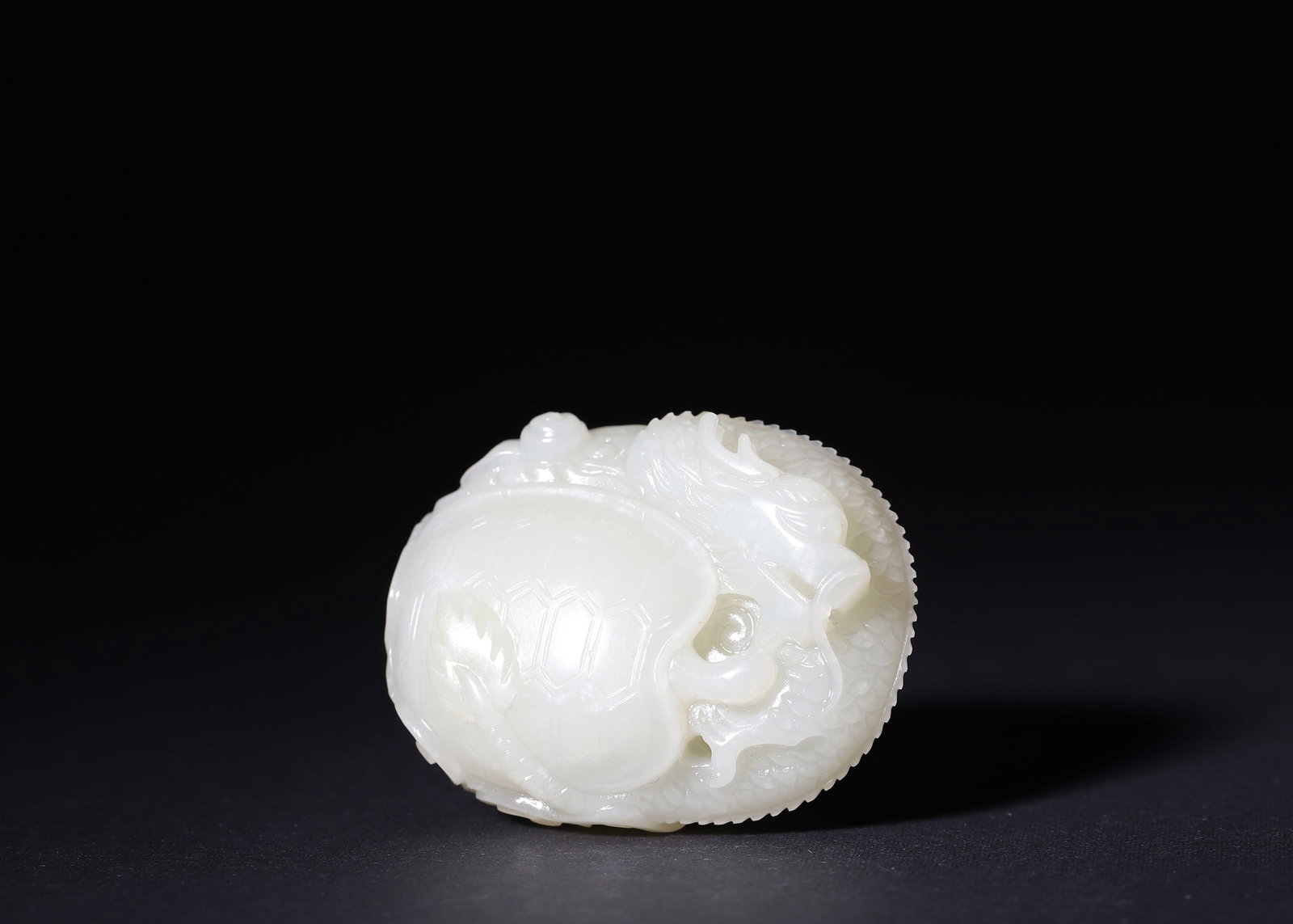 Qing Dynasty White Hetian Jade Carved Xuanwu Dragon Hand Ornament, C.17Th-19th Century: Oval hand-carved ornament of white Hetian seed jade. Obverse openwork Xuanwu tortoise intertwined with scaled dragon; reverse fully incised scrolling cloud dragon patterns with smooth hollow transitio