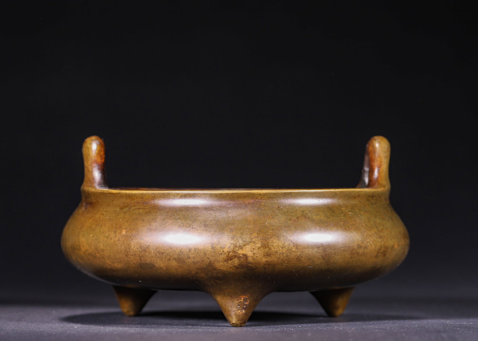 Qing Dynasty, Bronze Tripod Censer with Upright Loop Handles, Collector's Seal Mark: A bronze tripod censer of Qing Dynasty with two upright arched handles and three pointed solid feet. It bears an antique collector's seal mark on base, covered with smooth aged brown-gold patina, with