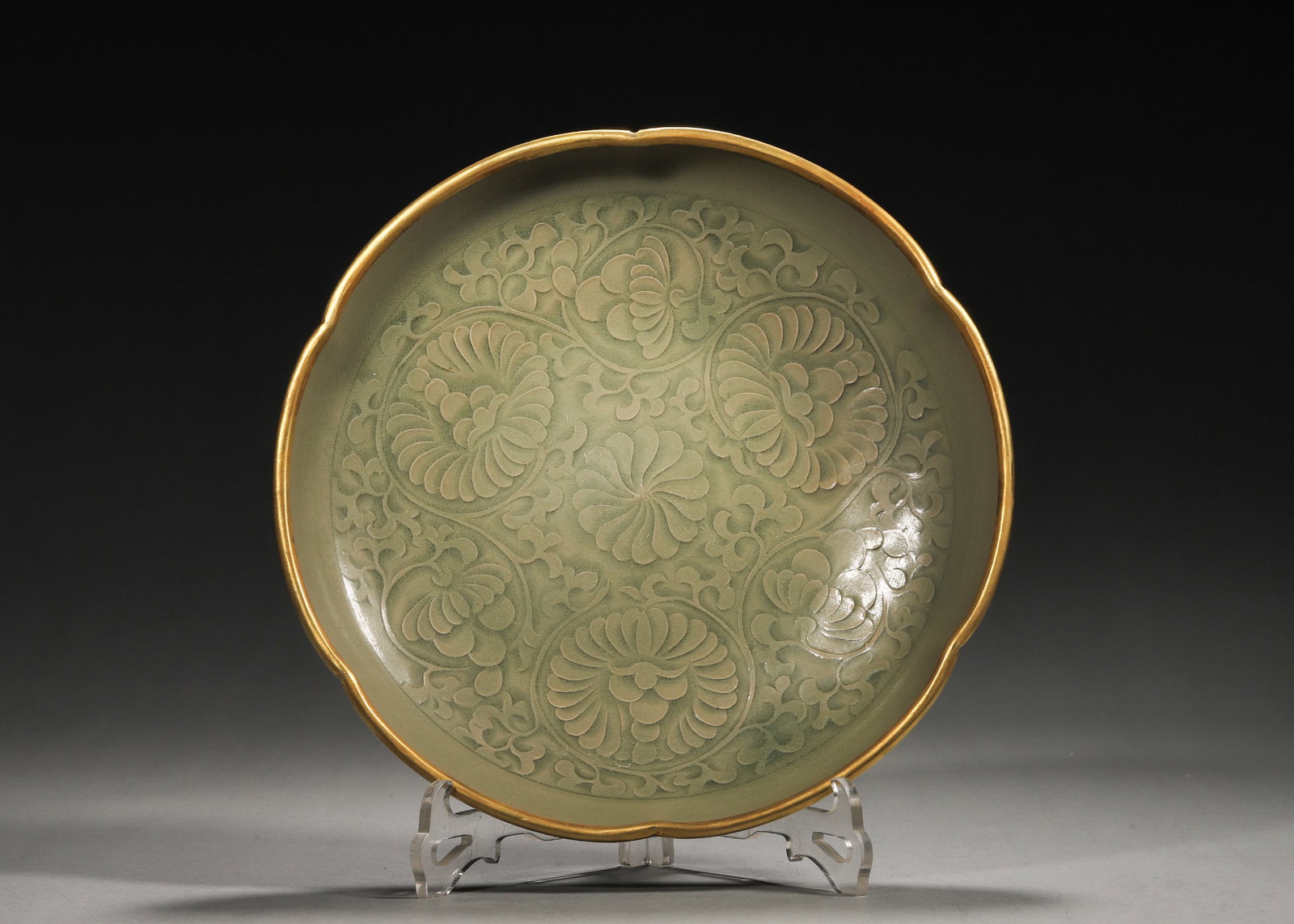 Yaozhou Kiln Celadon Carved Chrysanthemum Floral-Rim Plate (Northern Song, 960-1127): Floral-rim form with gilded rim. Interior carved with intertwined chrysanthemum patterns. Even celadon glaze. Plain exterior, unglazed base, typical Yaozhou ware of Northern Song. Dimensions: