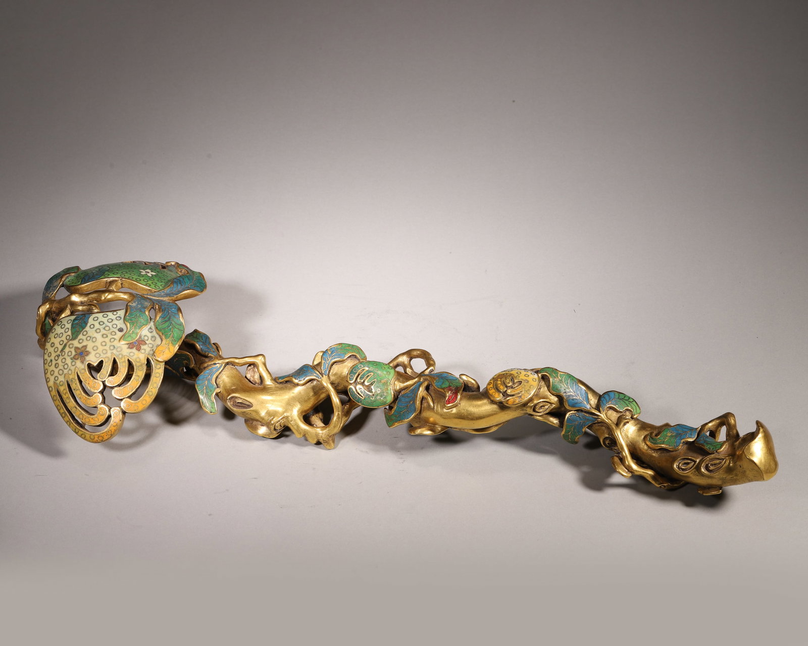 Qing Dynasty, Gilt Bronze Cloisonné Ruyi with Bergamot Design: This ruyi is made of gilt bronze with fine cloisonné enamel. Shaped as a bergamot (hand of Buddha), it features intricate filigree work and vivid enamel colors, with the stem bearing a "Qianlong Nian