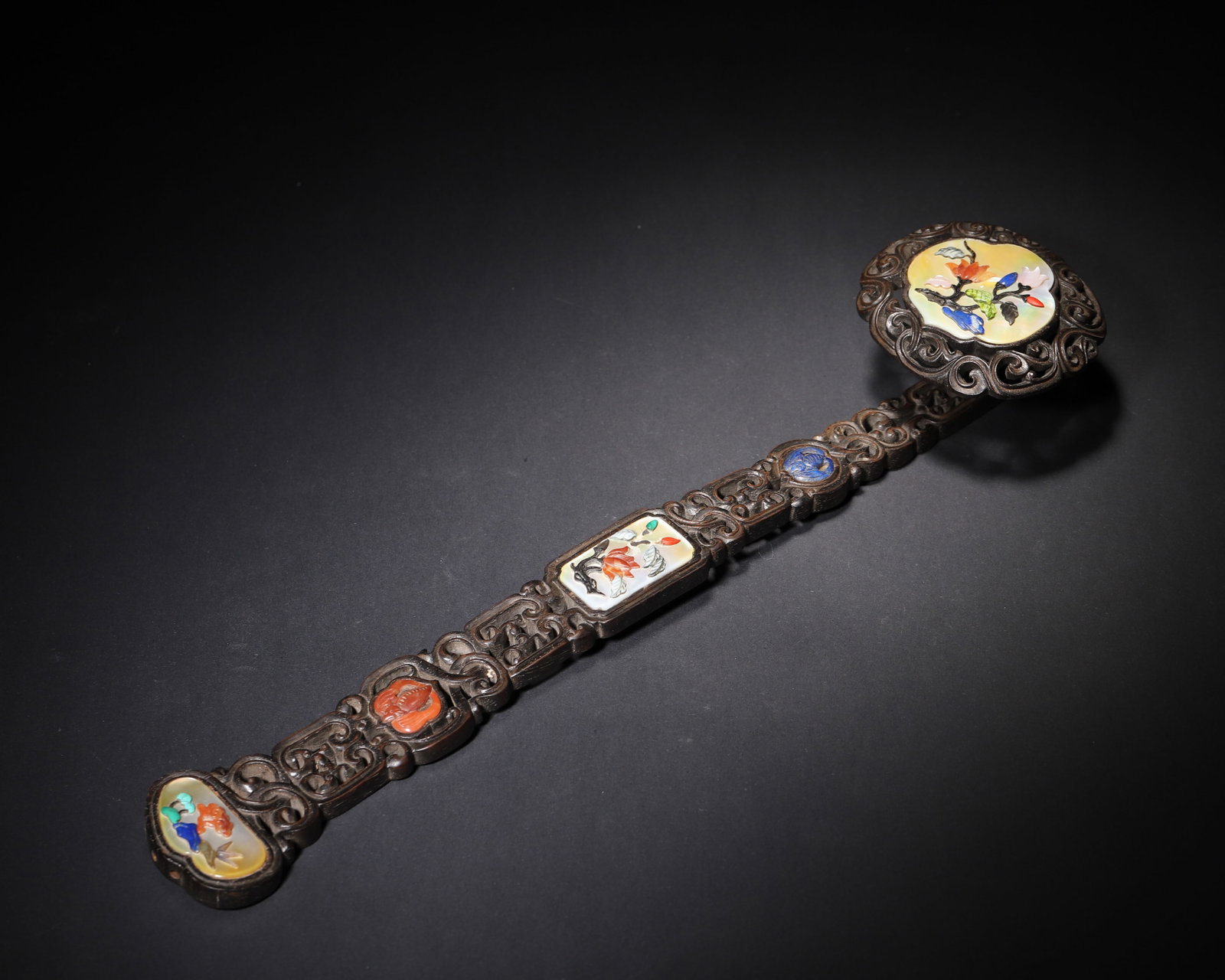 Qing Dynasty (Qianlong Period), a Hongmu Wood Ruyi with Hardstone Inlay: An exceptional imperial ruyi from the Qianlong period, featuring Hongmu wood carved with openwork scrolls, inlaid with mother of pearl and hardstones to depict floral motifs. A masterpiece of Qing imp